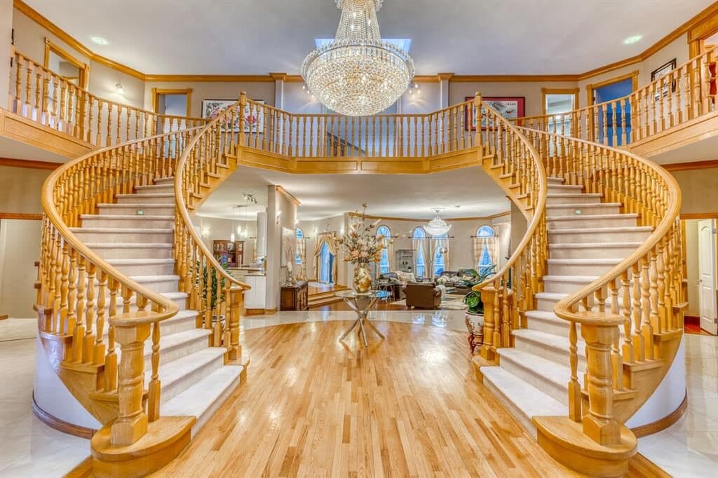 Gargoyle House foyer in 2023 — original golden oak double staircase
