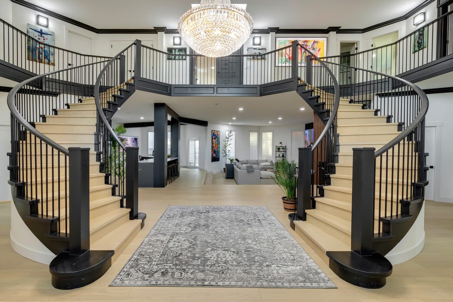 Rebuilt Gargoyle House foyer with twin curved staircases and custom chandelier