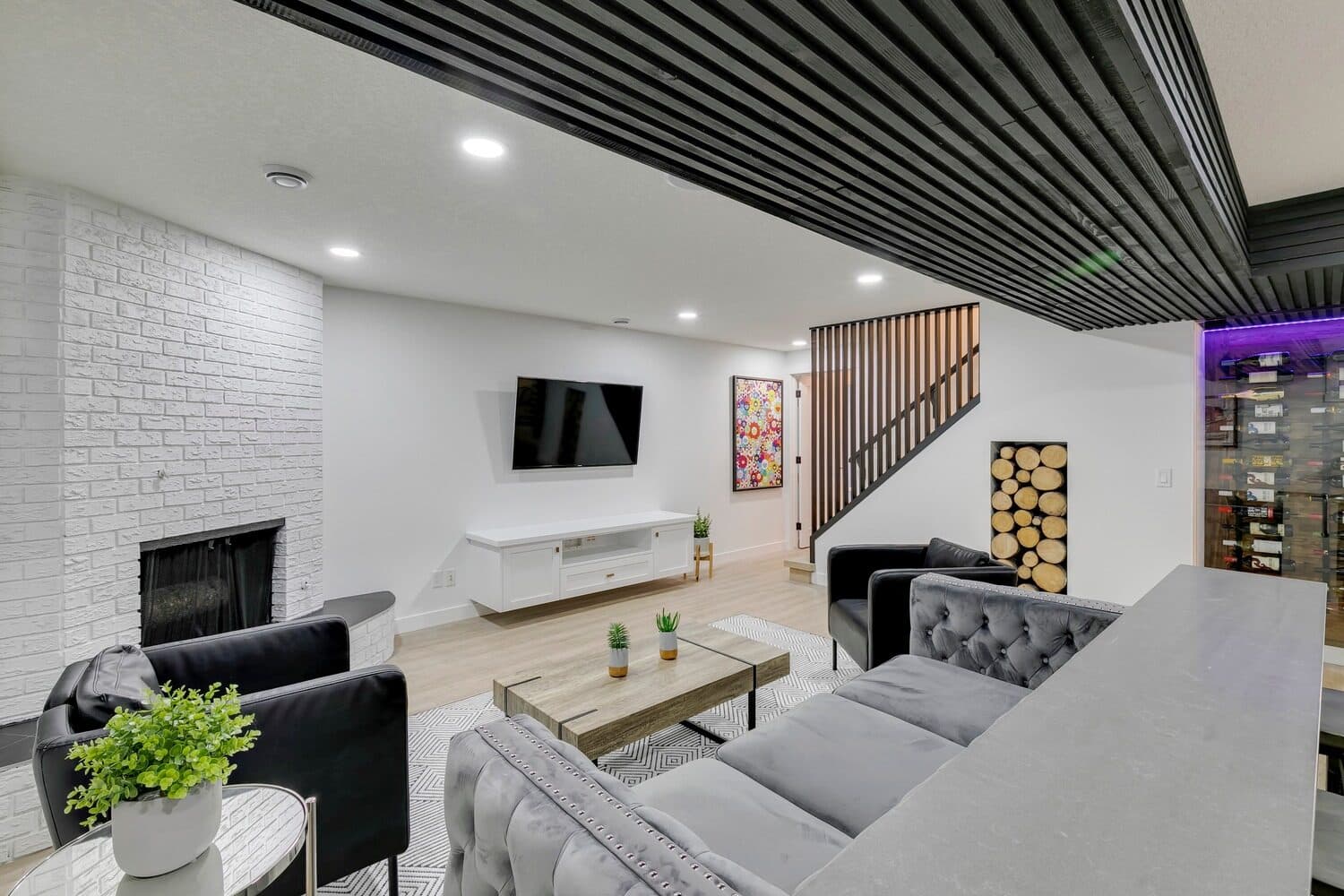 Bannerman Drive basement lounge with white brick fireplace