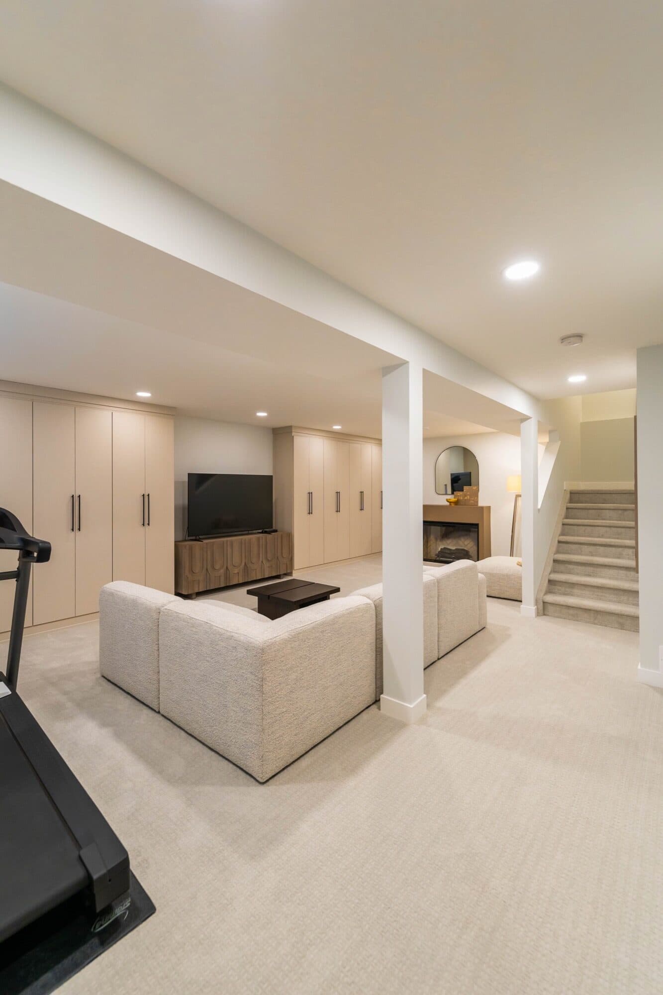 Spacious finished basement with built-in cabinetry, a fireplace and a home-gym area