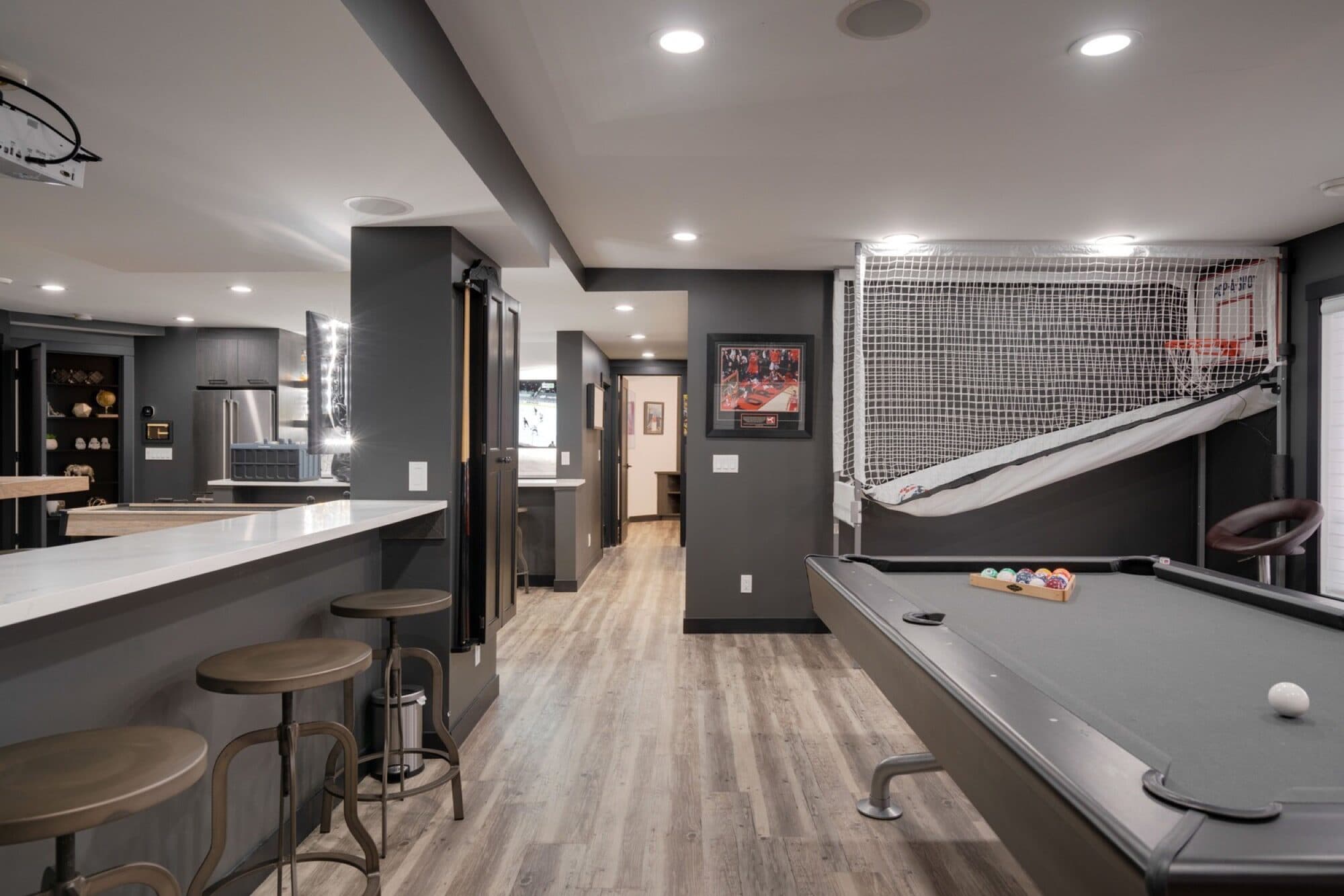Basement rec room with pool table and shiplap fireplace feature wall