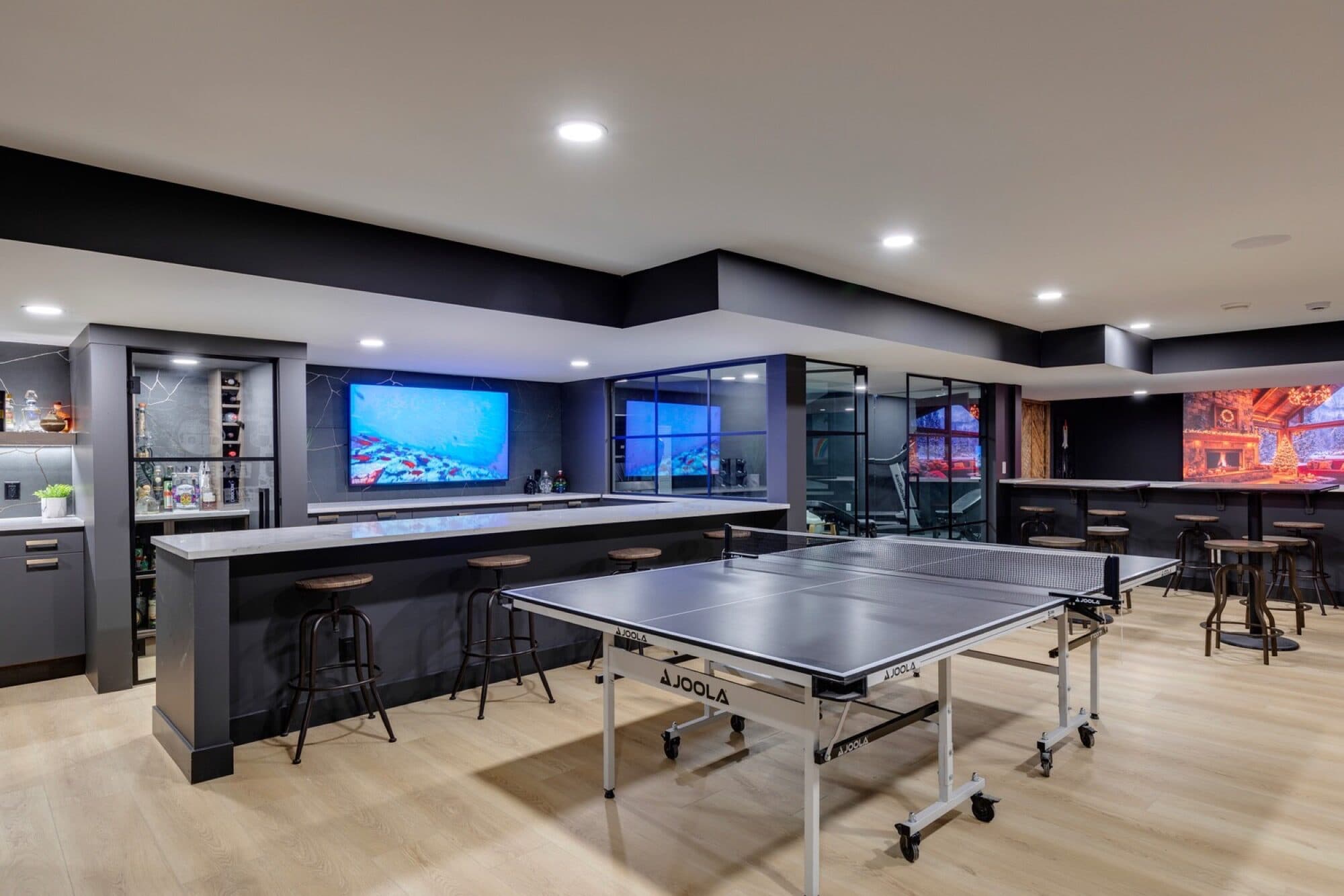 Basement bar and games area with ping pong and aquarium display screens