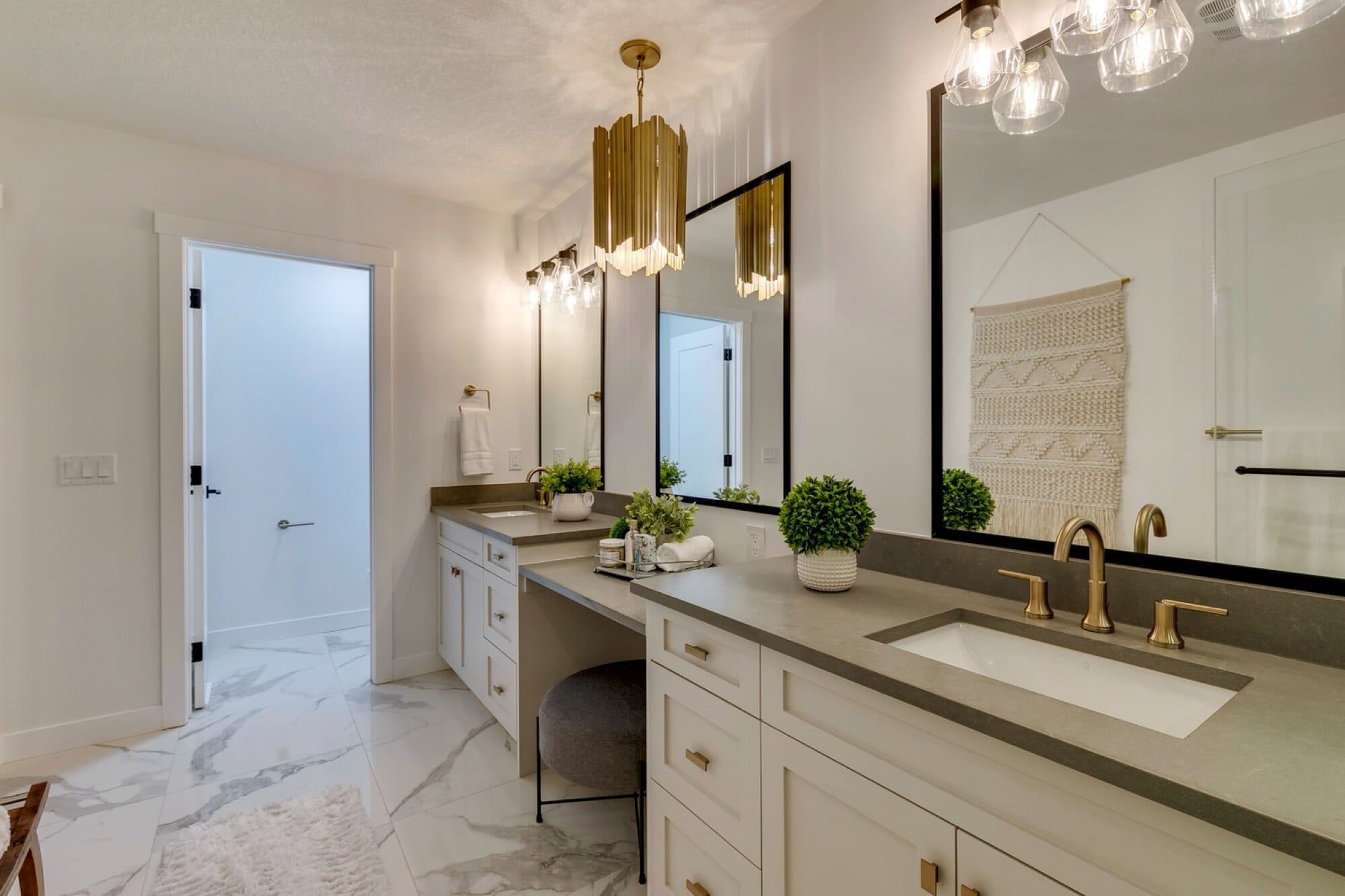 Ensuite double vanity with gold fixtures and pendant chandelier
