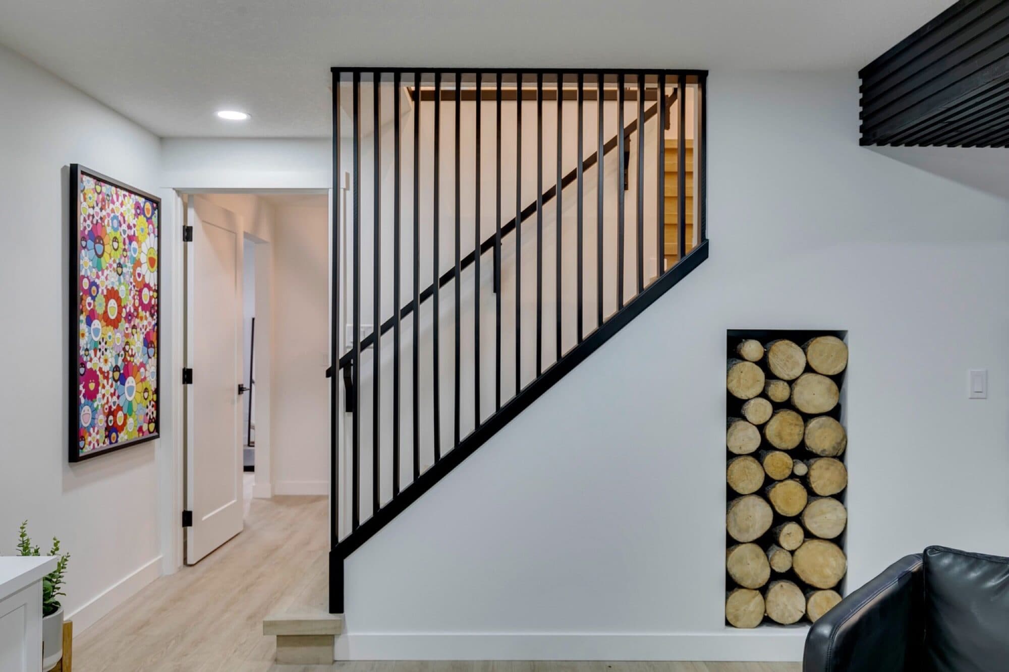 Modern basement staircase with steel railing and log niche