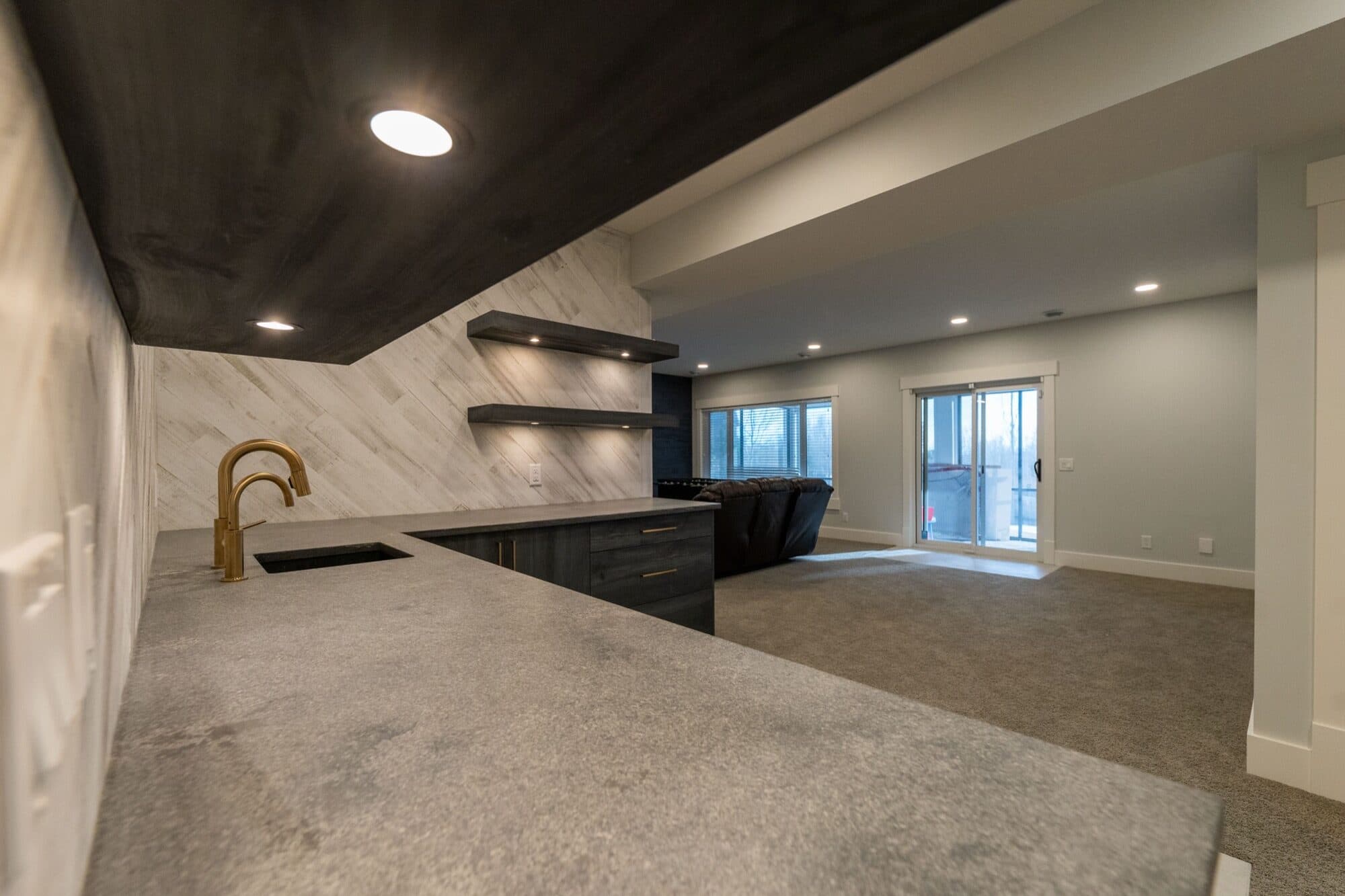 Bold black-ceiling bar with marble backsplash and brass faucet