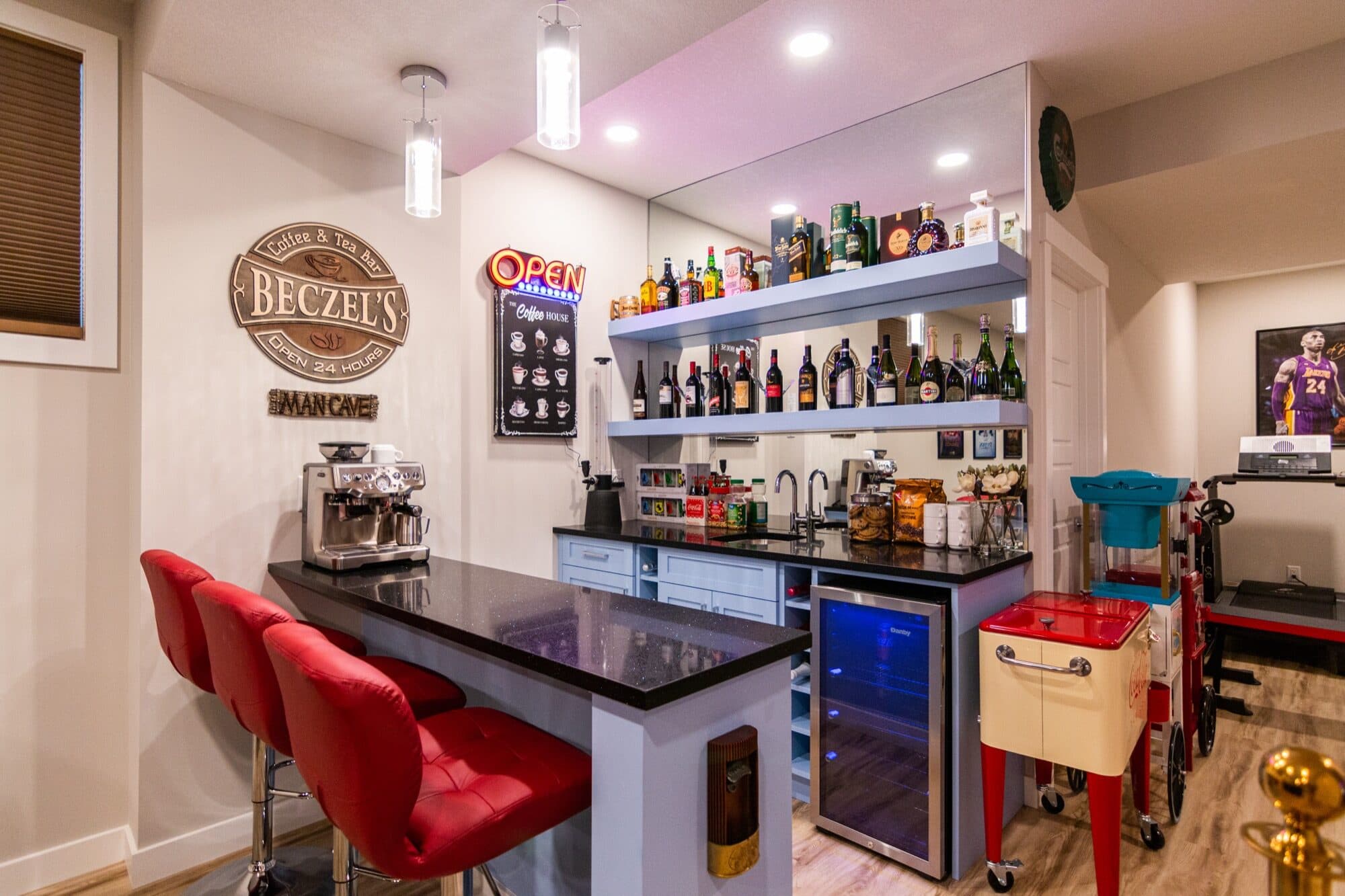 Personalised basement bar with neon sign, red stools and wine shelving
