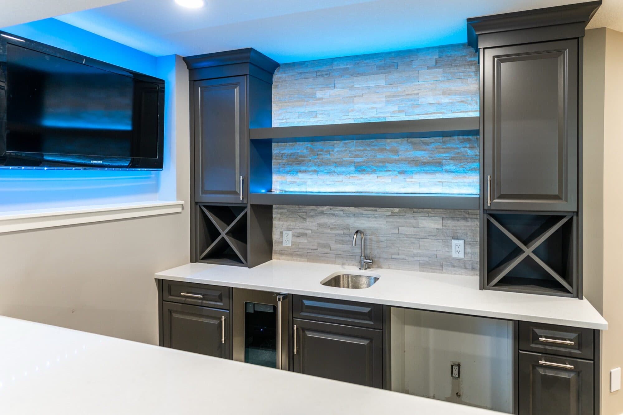 Dark basement bar with LED backsplash and stone tile wall