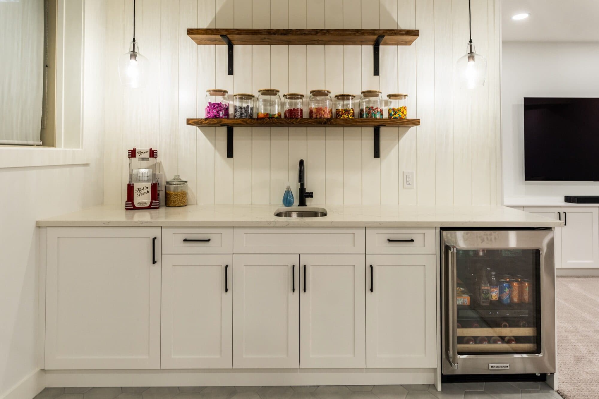 Farmhouse basement wet bar with shiplap, open shelving and wine fridge
