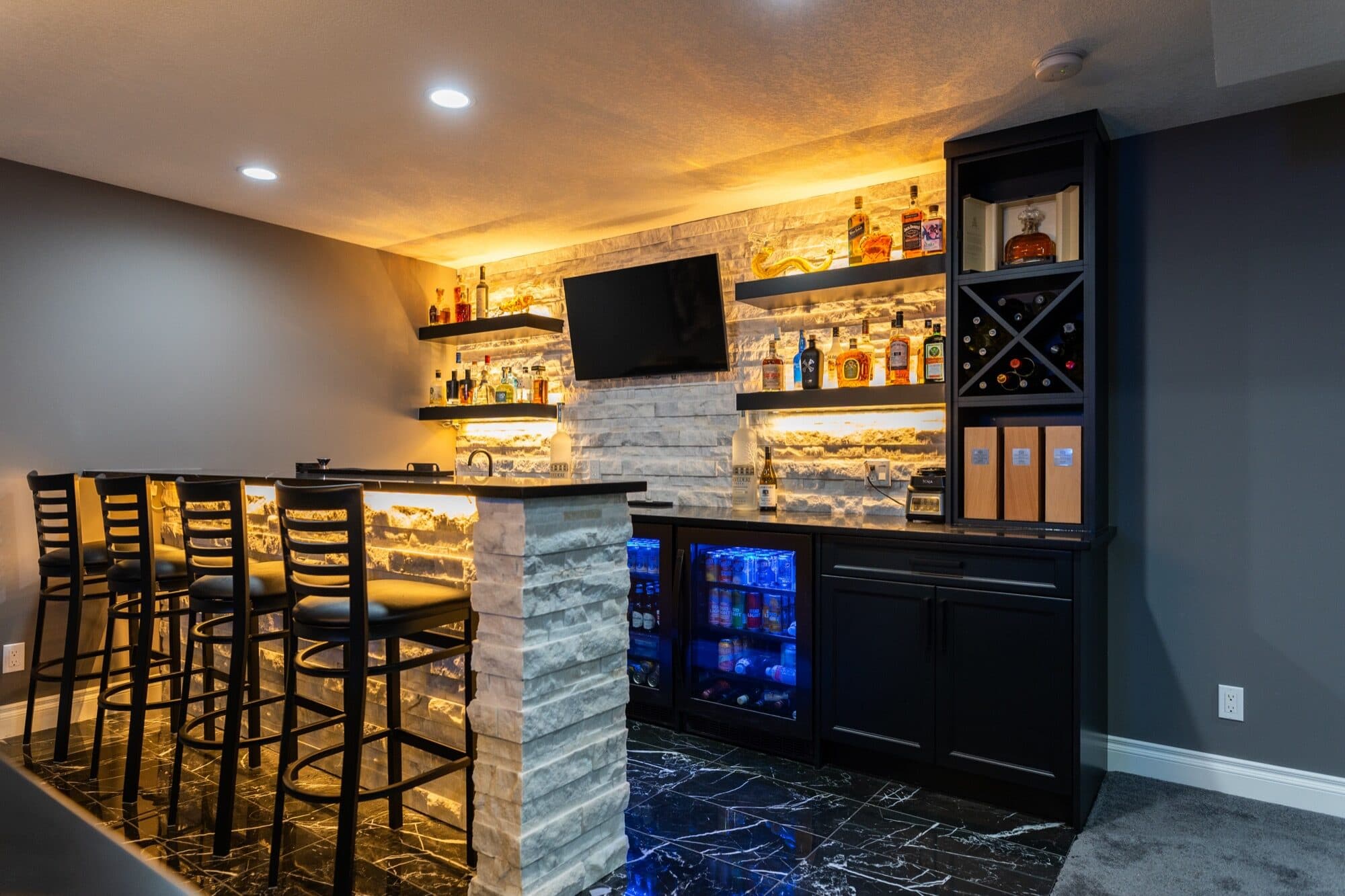 Basement bar side angle with wine rack, fridge and stone column