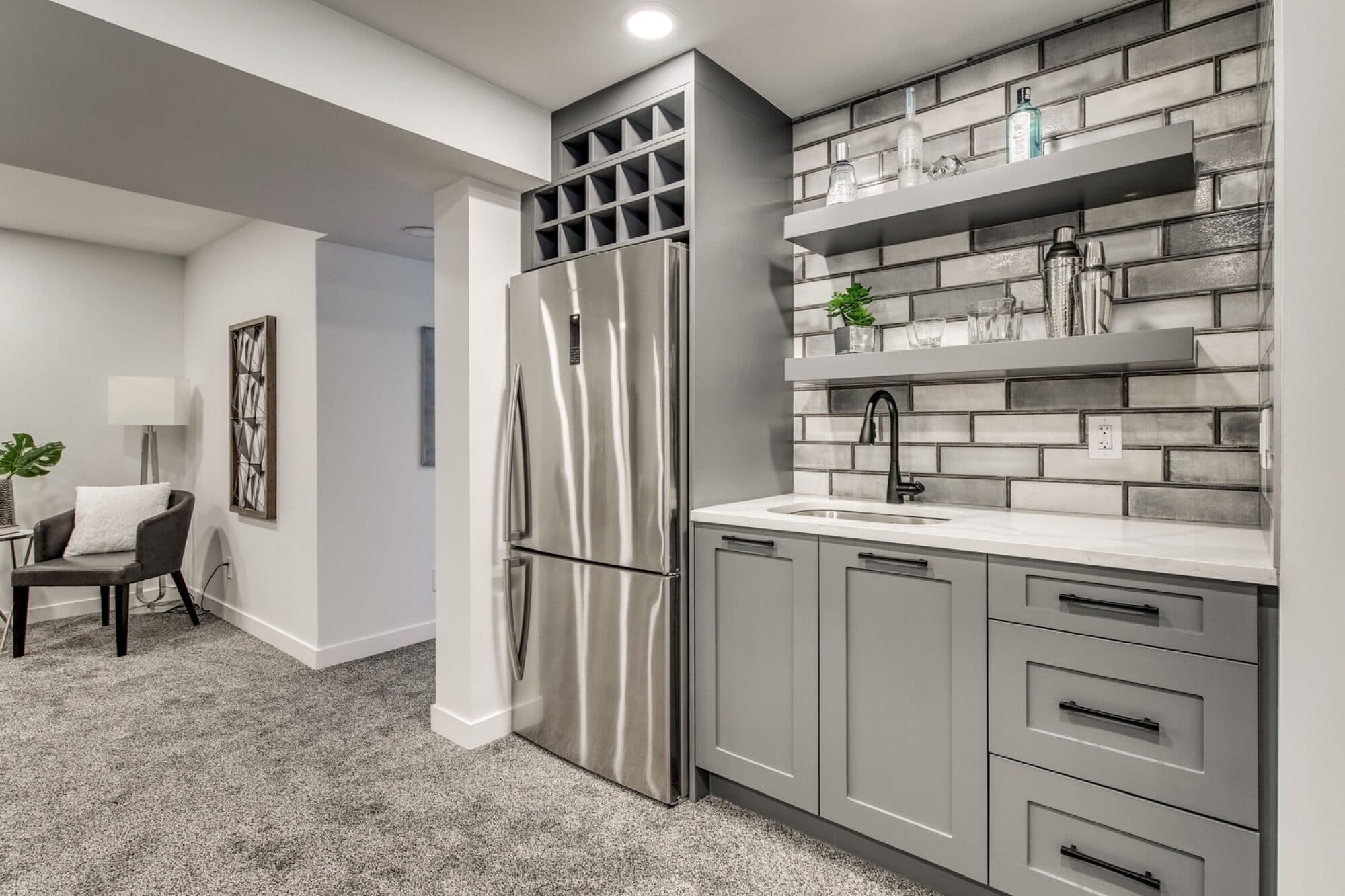 Basement bar with grey brick tile backsplash and wine rack