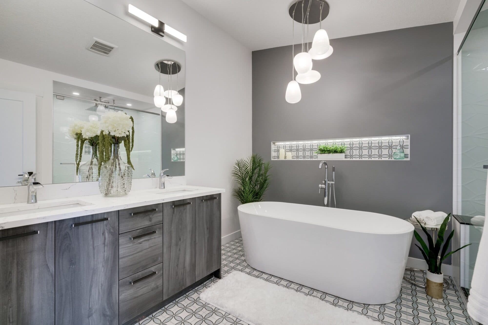 Ensuite with freestanding soaker tub, pendant lights and patterned floor