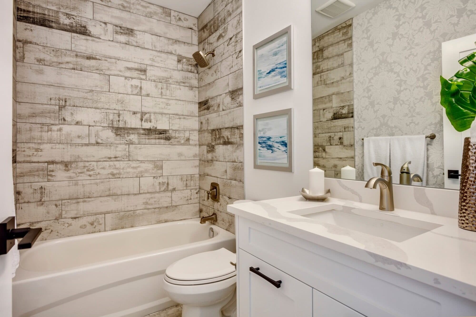 Bathroom with reclaimed wood plank tile tub surround and damask wall