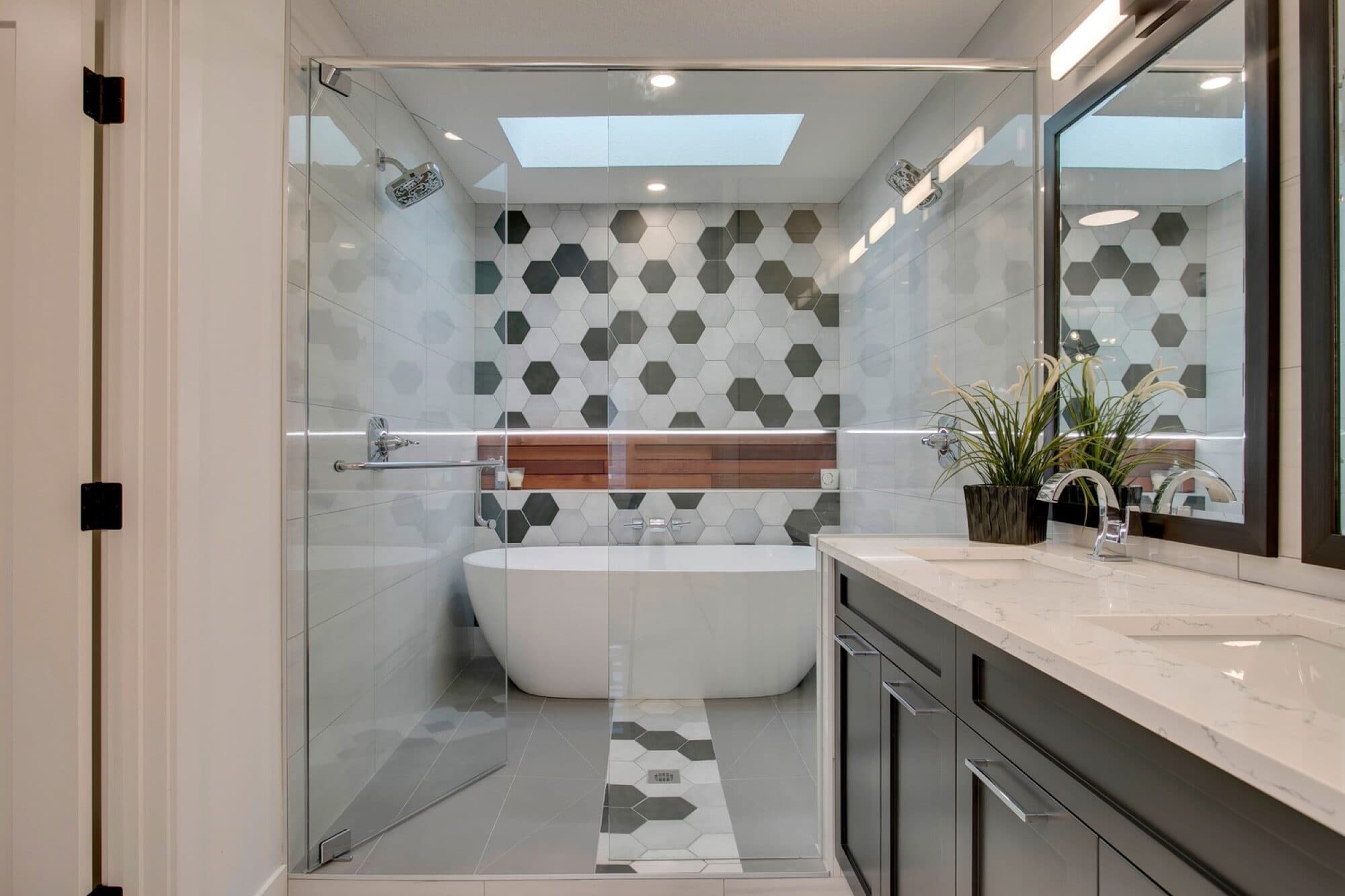 Ensuite with hexagon tile wall, freestanding tub and grey vanity