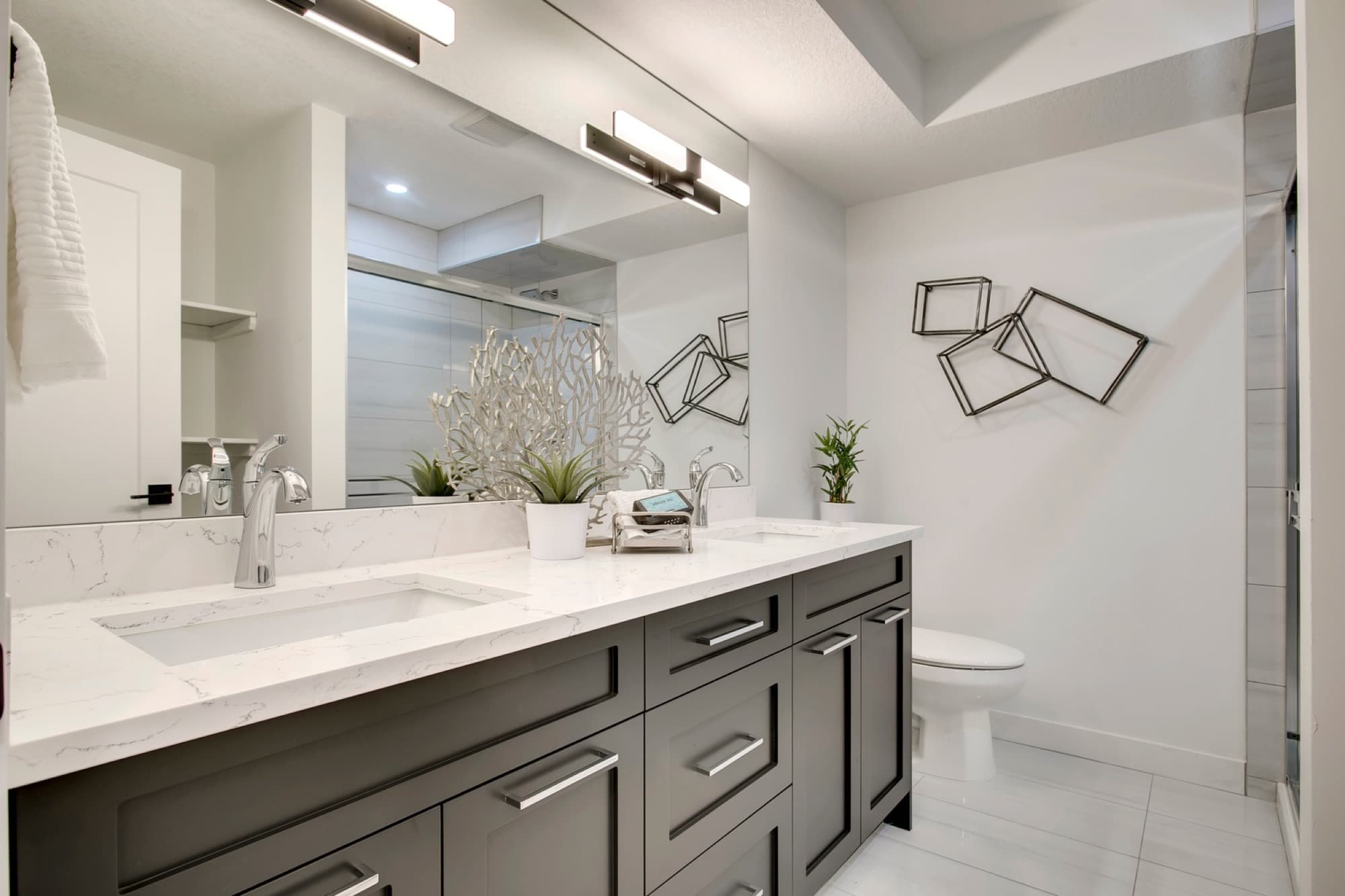 Basement bathroom with double vanity, quartz countertop and glass shower