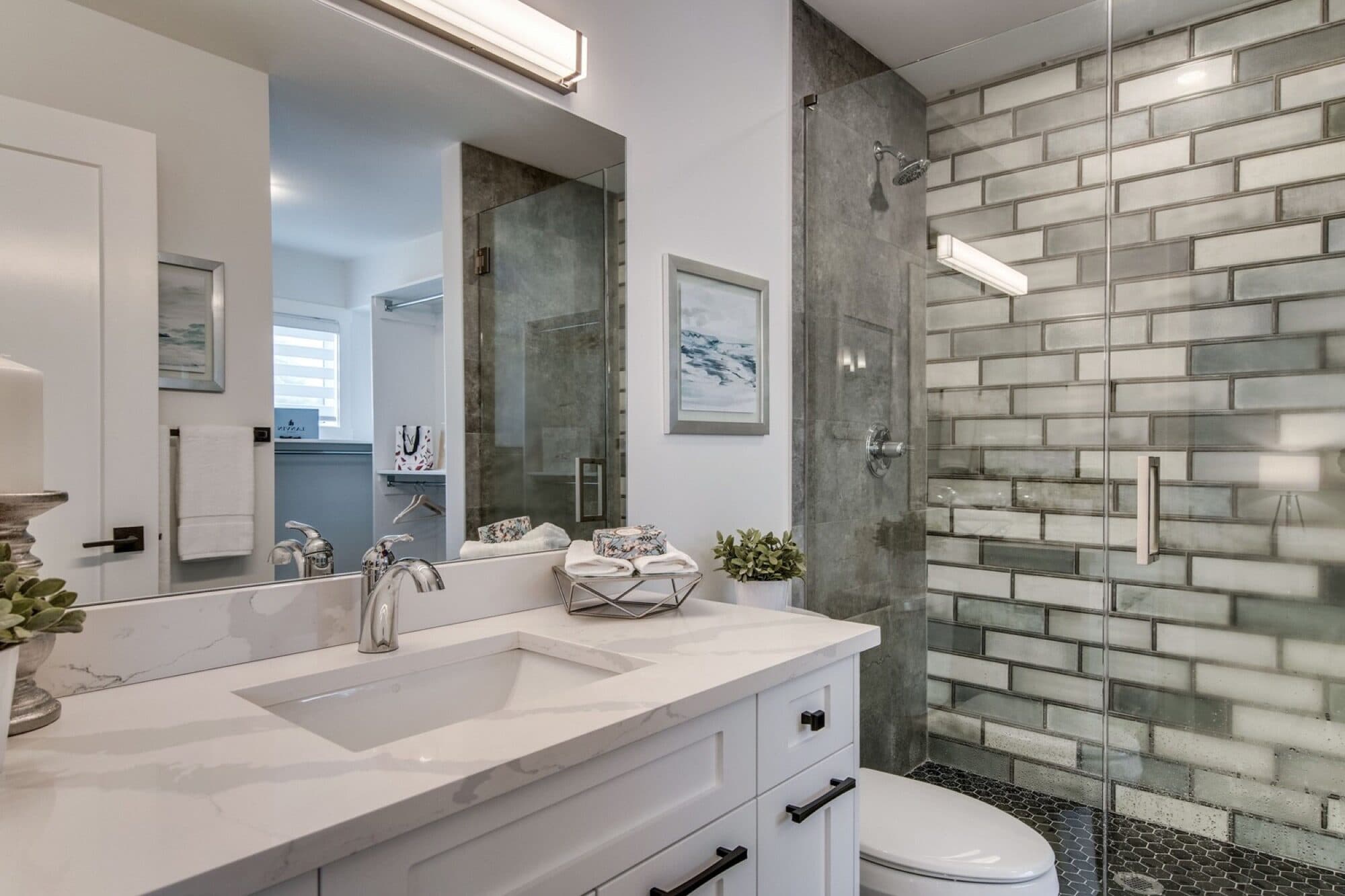 Basement bathroom with subway tile shower and white vanity