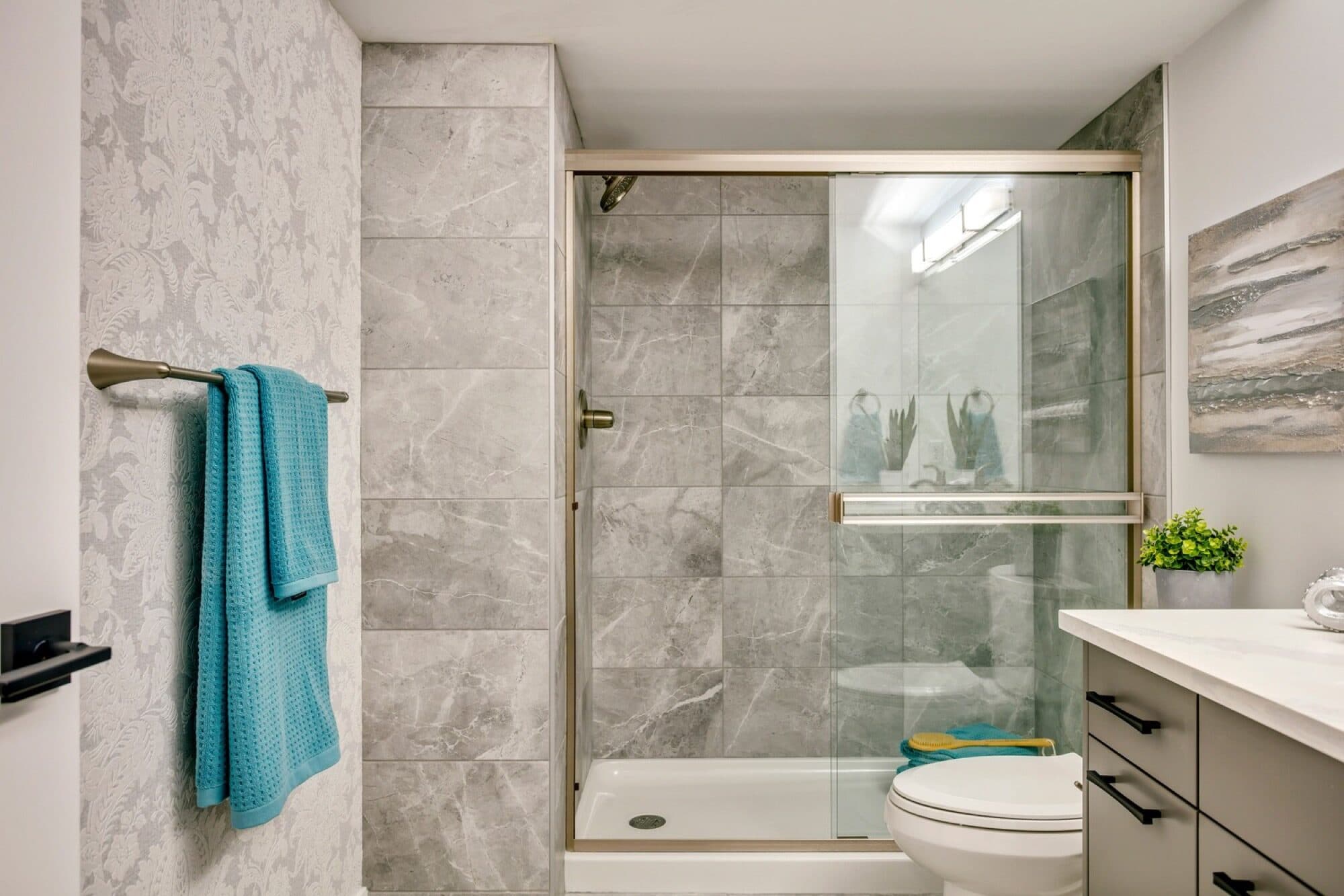 Basement bathroom with grey marble shower and floral wallpaper