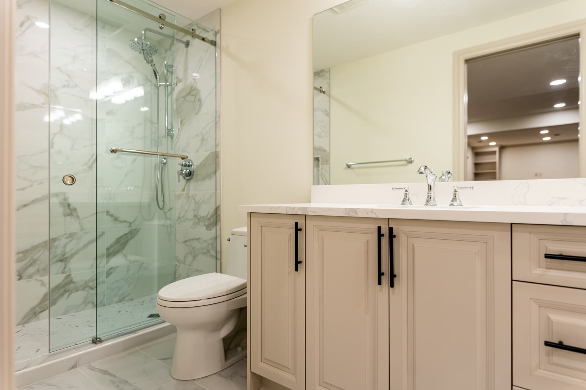 Elegant basement bathroom with marble shower, quartz vanity and chrome