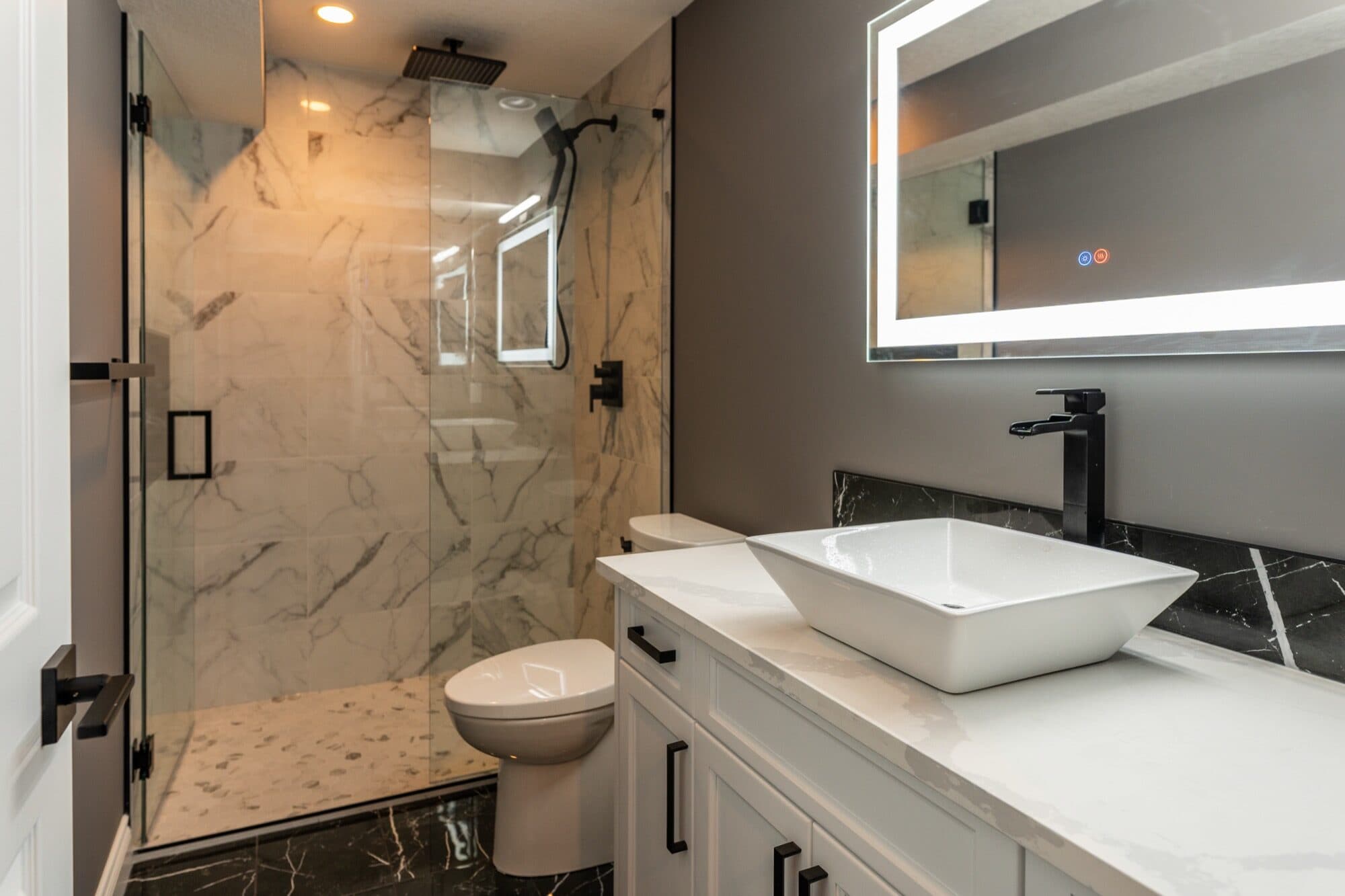 Full-room luxury basement bathroom with marble tile and vessel sink