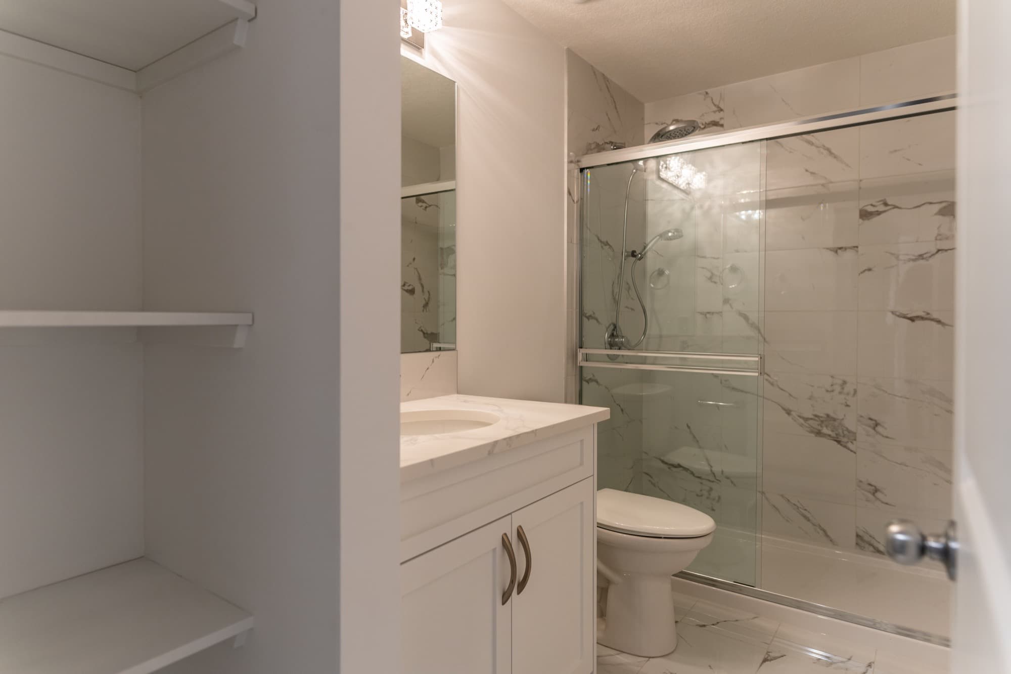 Basement legal suite bathroom with marble shower and open linen closet