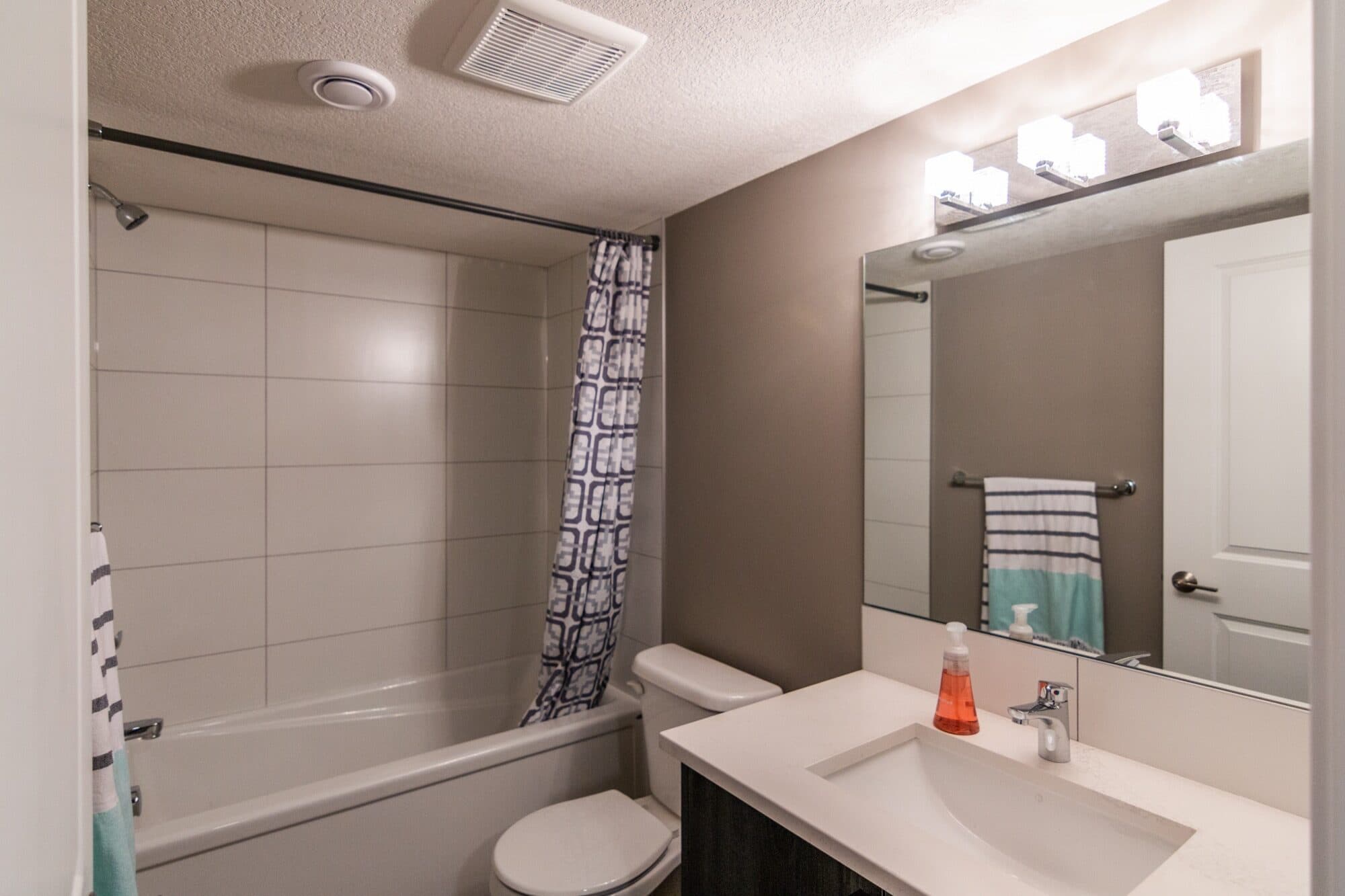 Legal suite bathroom with marble tile tub-shower and crystal light fixture