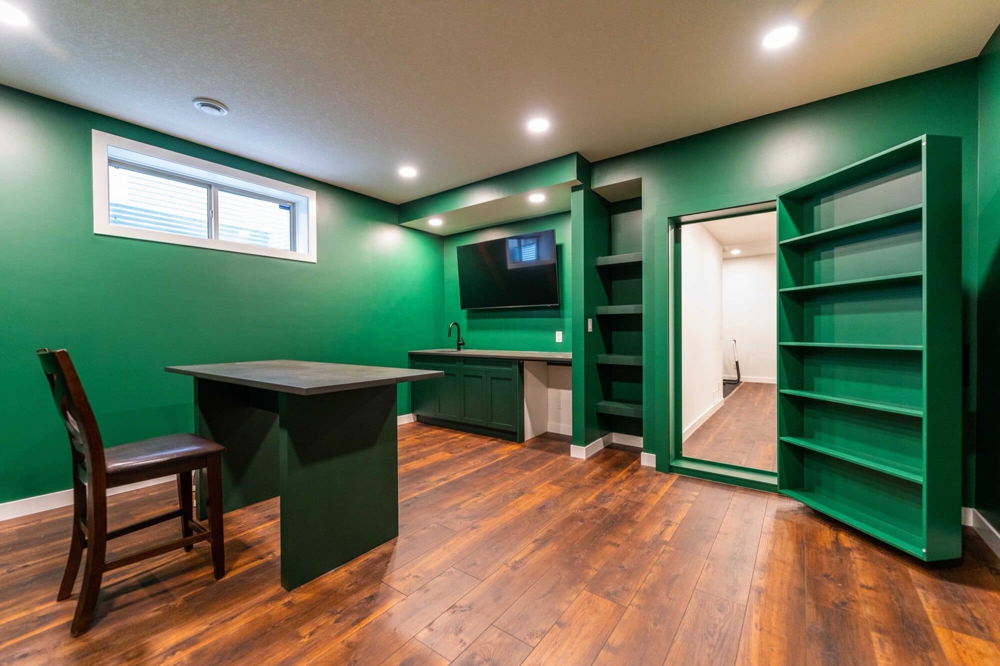 Basement green accent bar nook with a concealed bookcase secret door