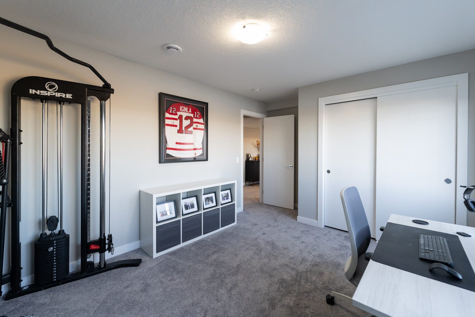Basement home gym with cable machine and carpet flooring