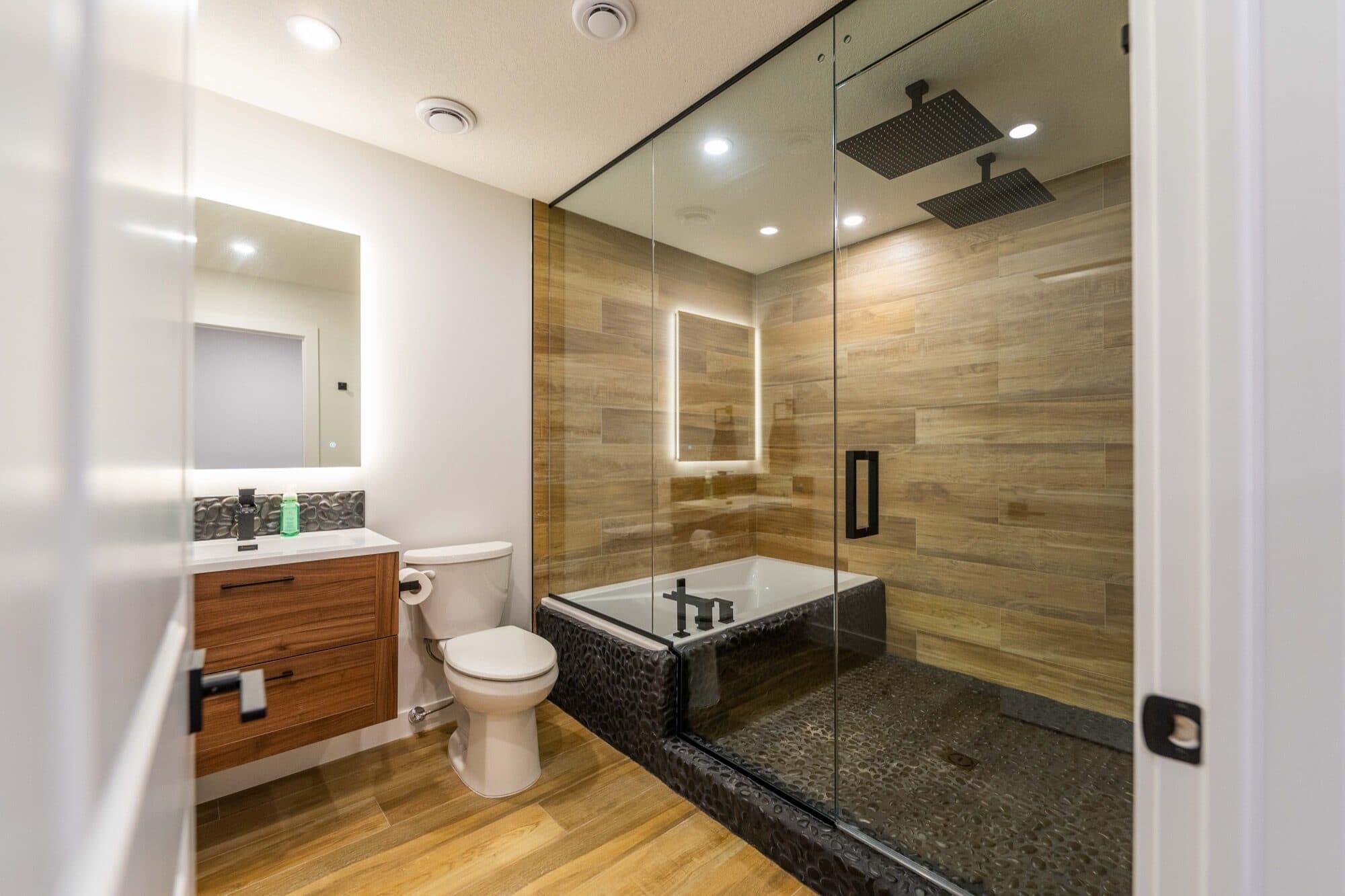 Basement spa bathroom full view with floating walnut vanity and glass shower