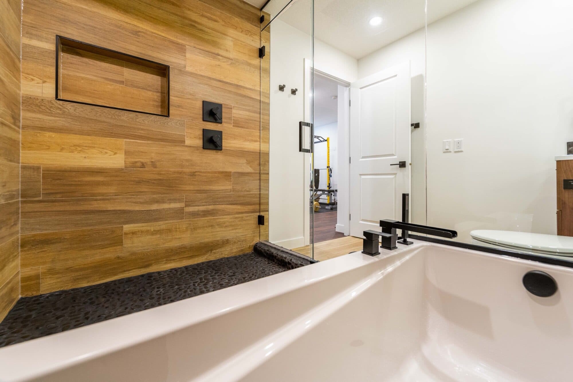 Basement spa bathroom with soaker tub and wood tile shower wall