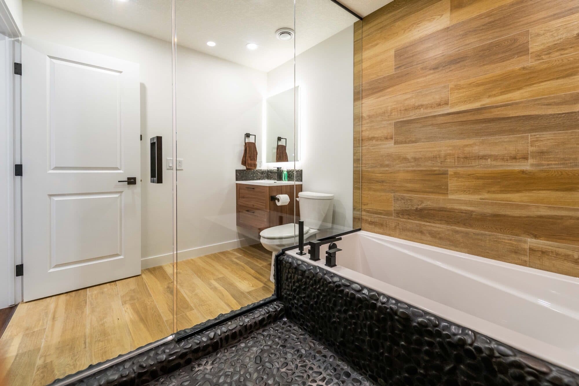 Basement spa bathroom wide angle with wood tile and glass shower partition