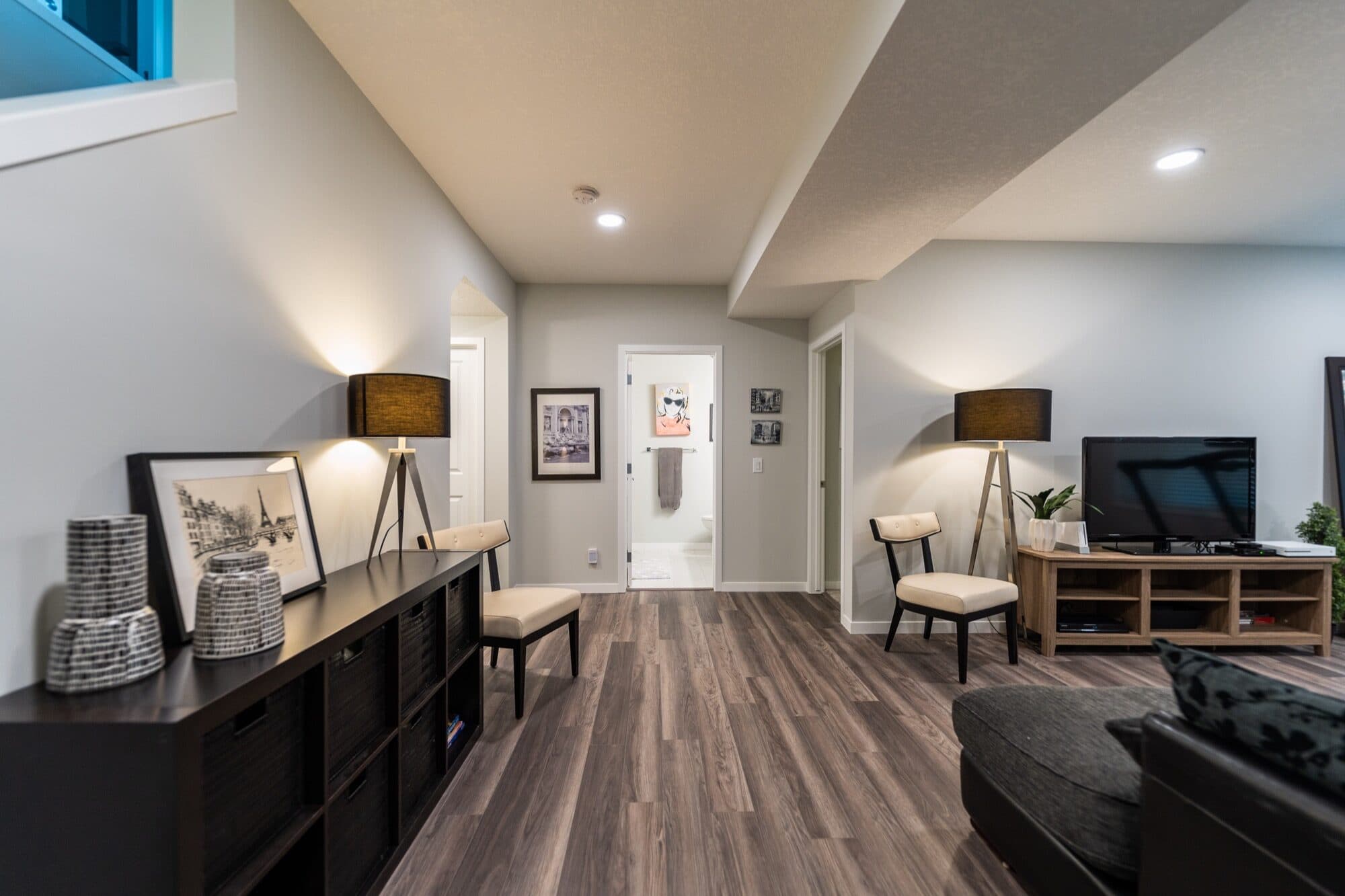 Basement open rec room looking toward the TV and bathroom hallway