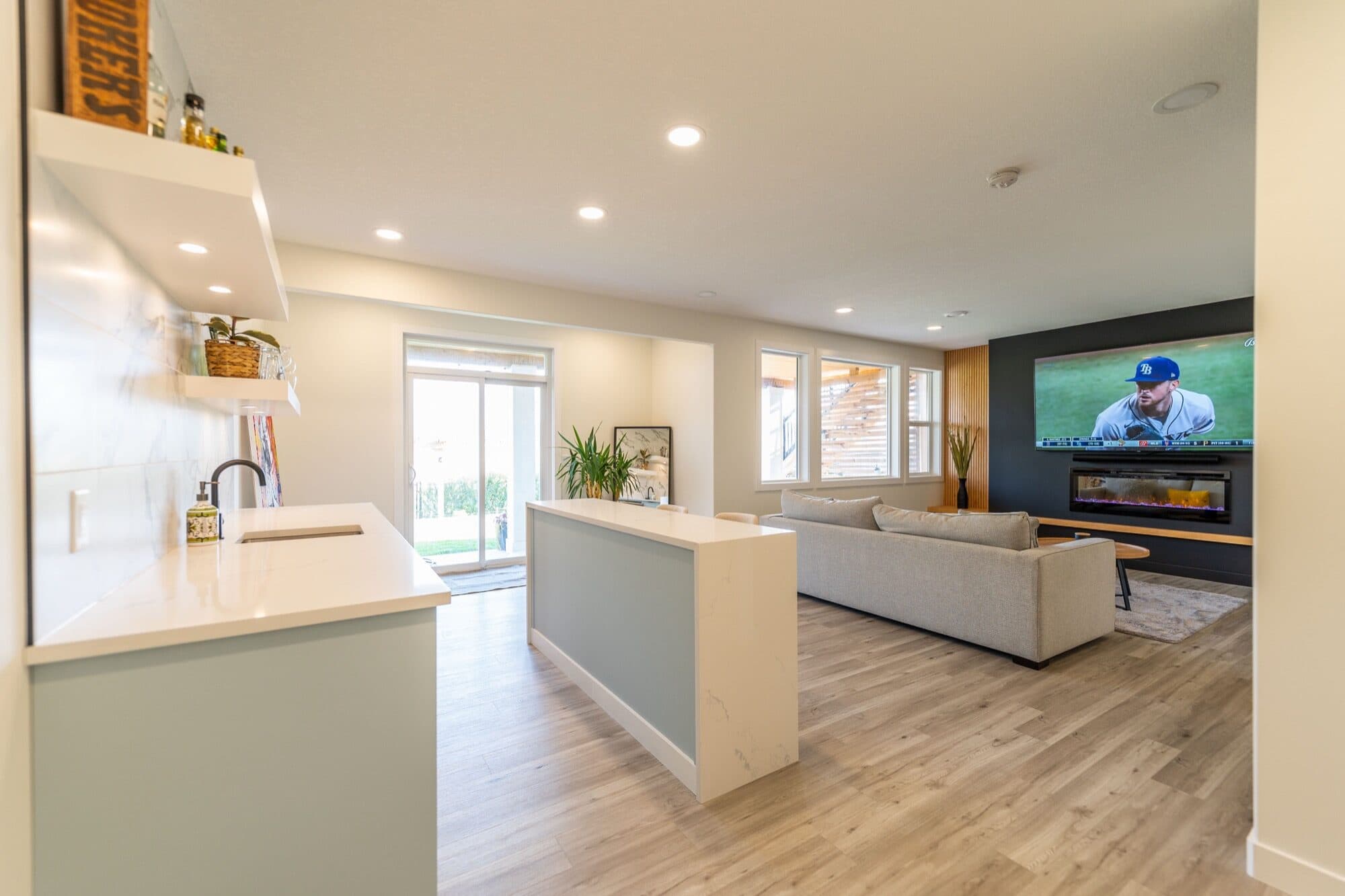 Basement open-plan rec room with wet bar area and walkout windows