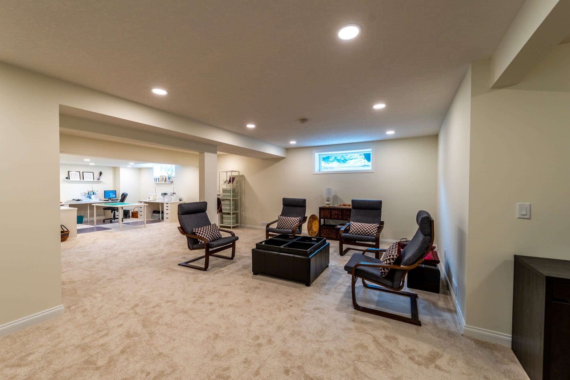 Basement open-plan rec room with chairs and home office area