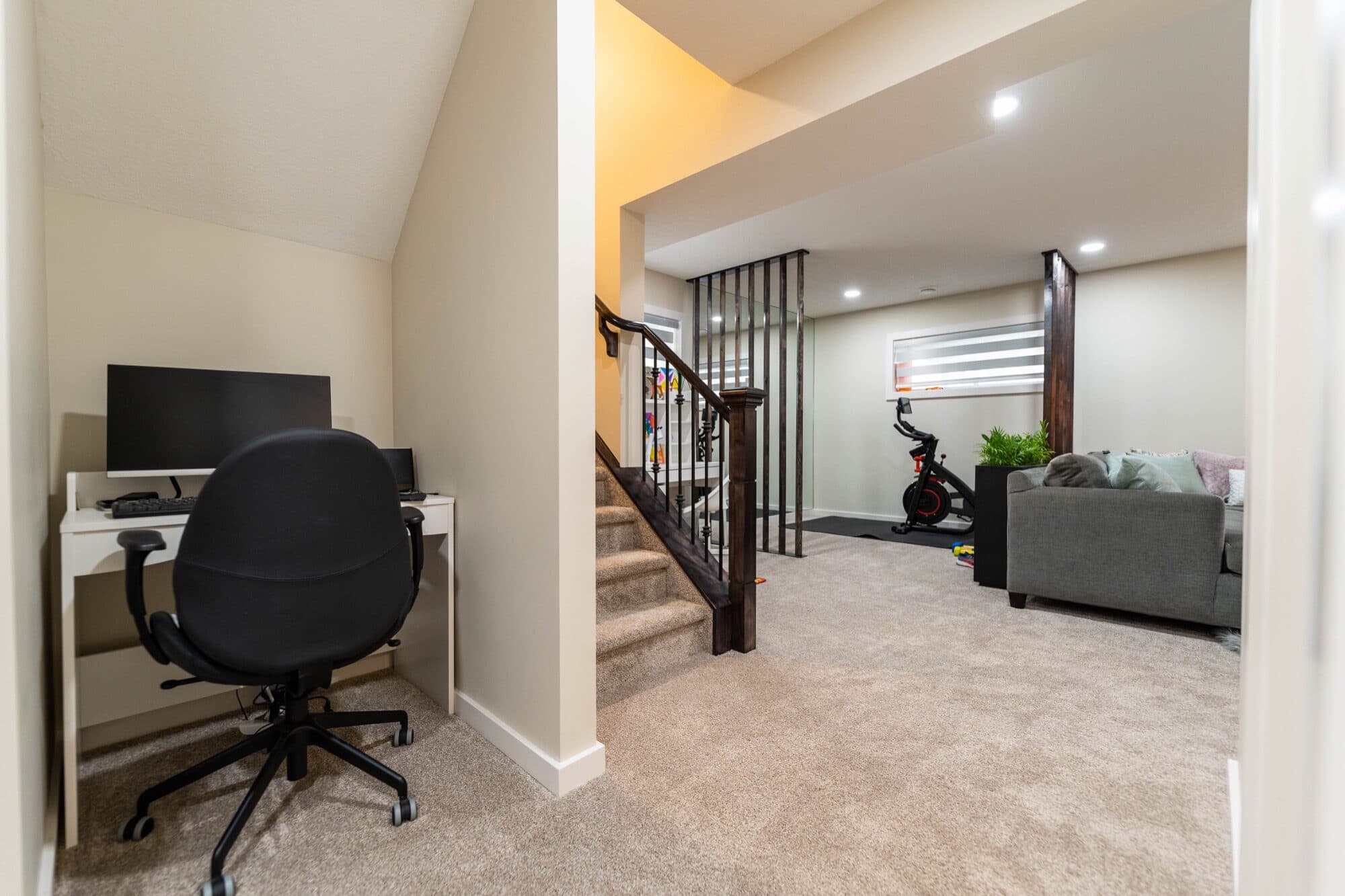 Basement rec room with piano, slatted wood divider and gym beyond