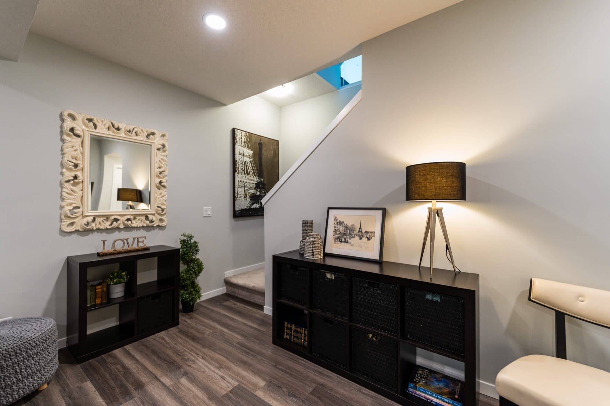 Basement reading nook under the staircase with lamp and storage shelves