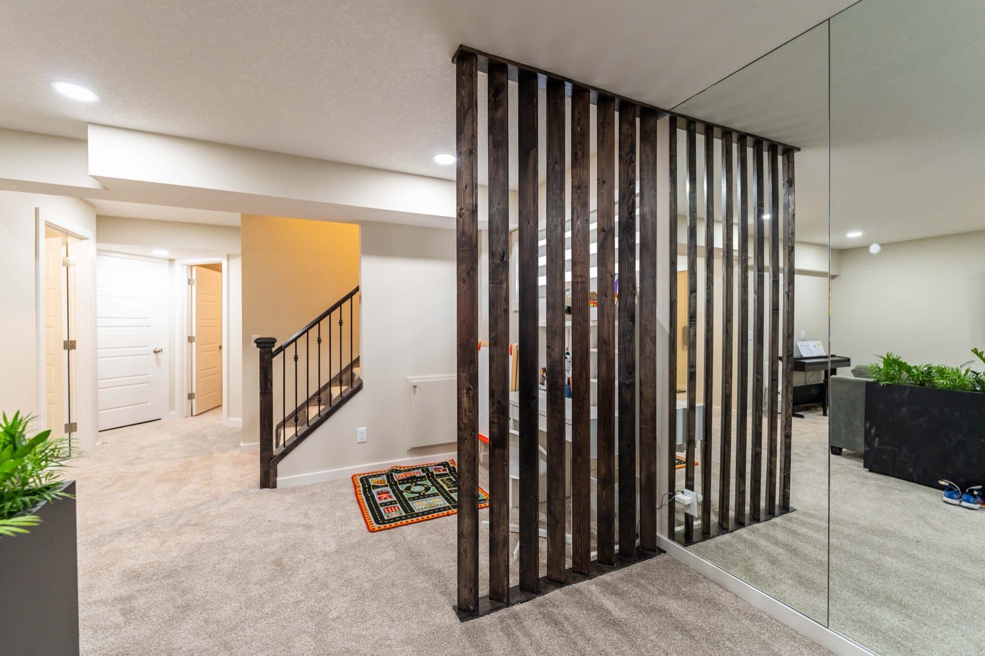 Basement rec room with slatted divider wall and staircase angle