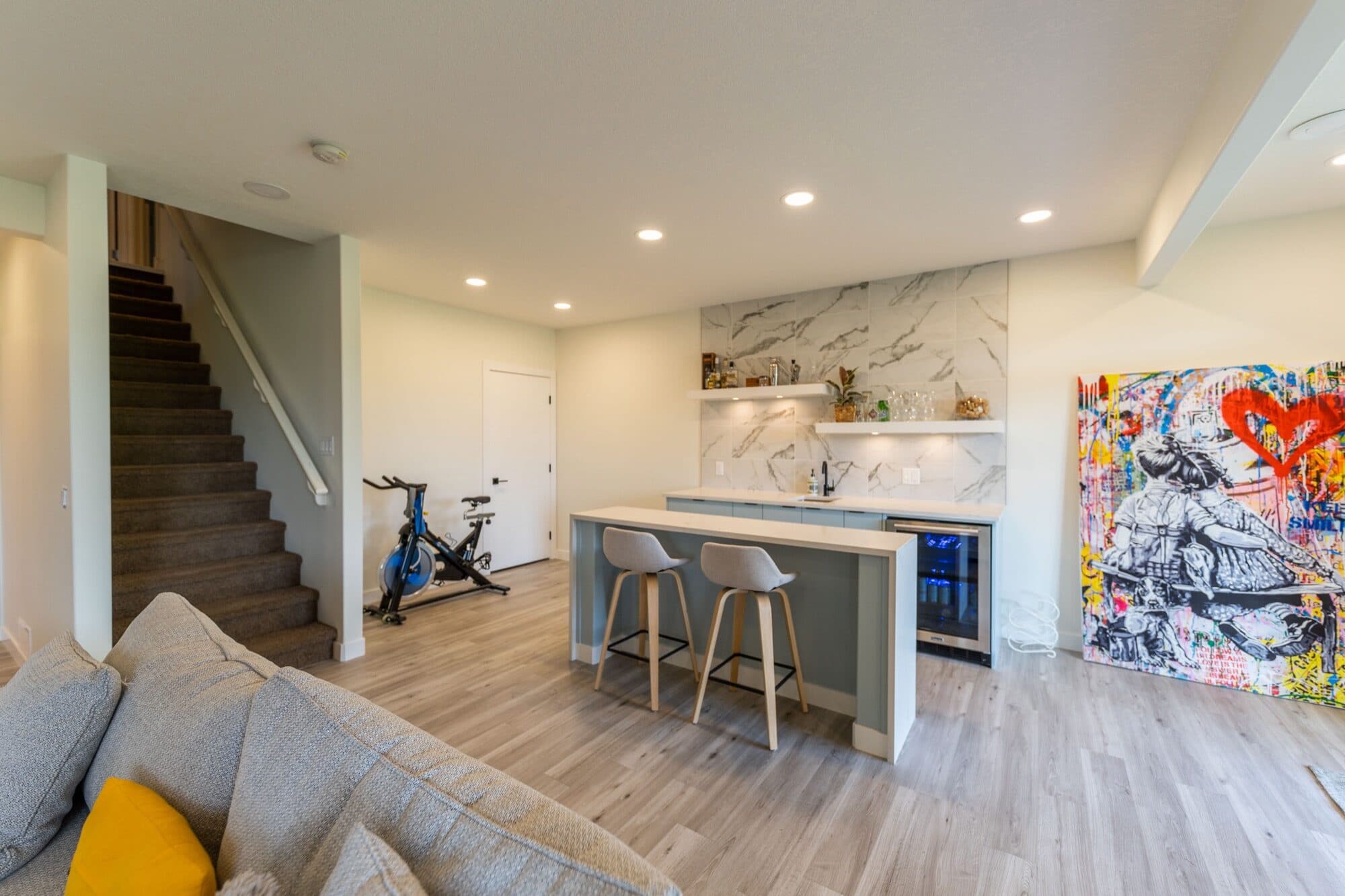Basement wet bar with marble backsplash viewed from the living area