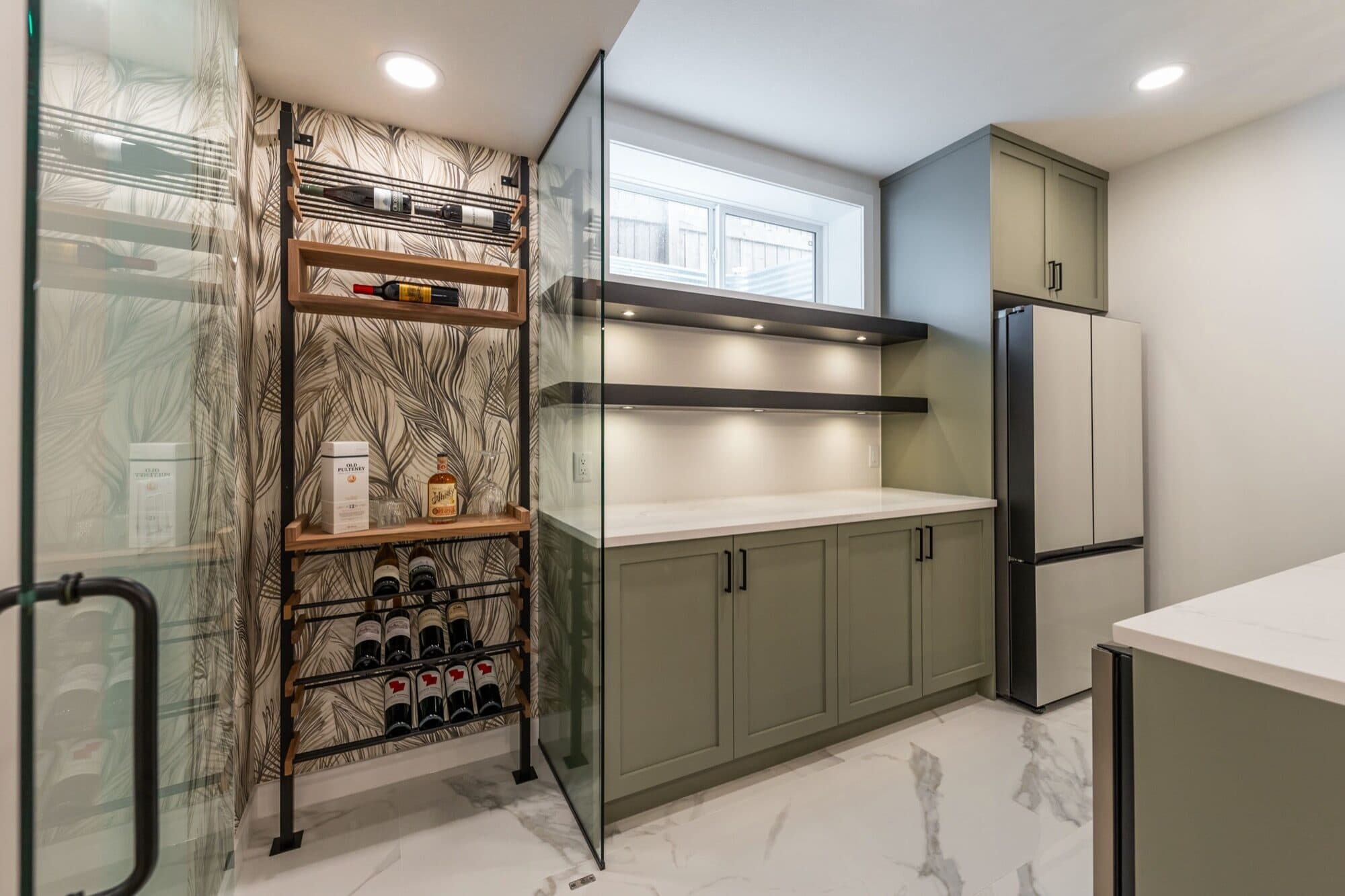 Basement bar with sage cabinets and glass wine room, back angle