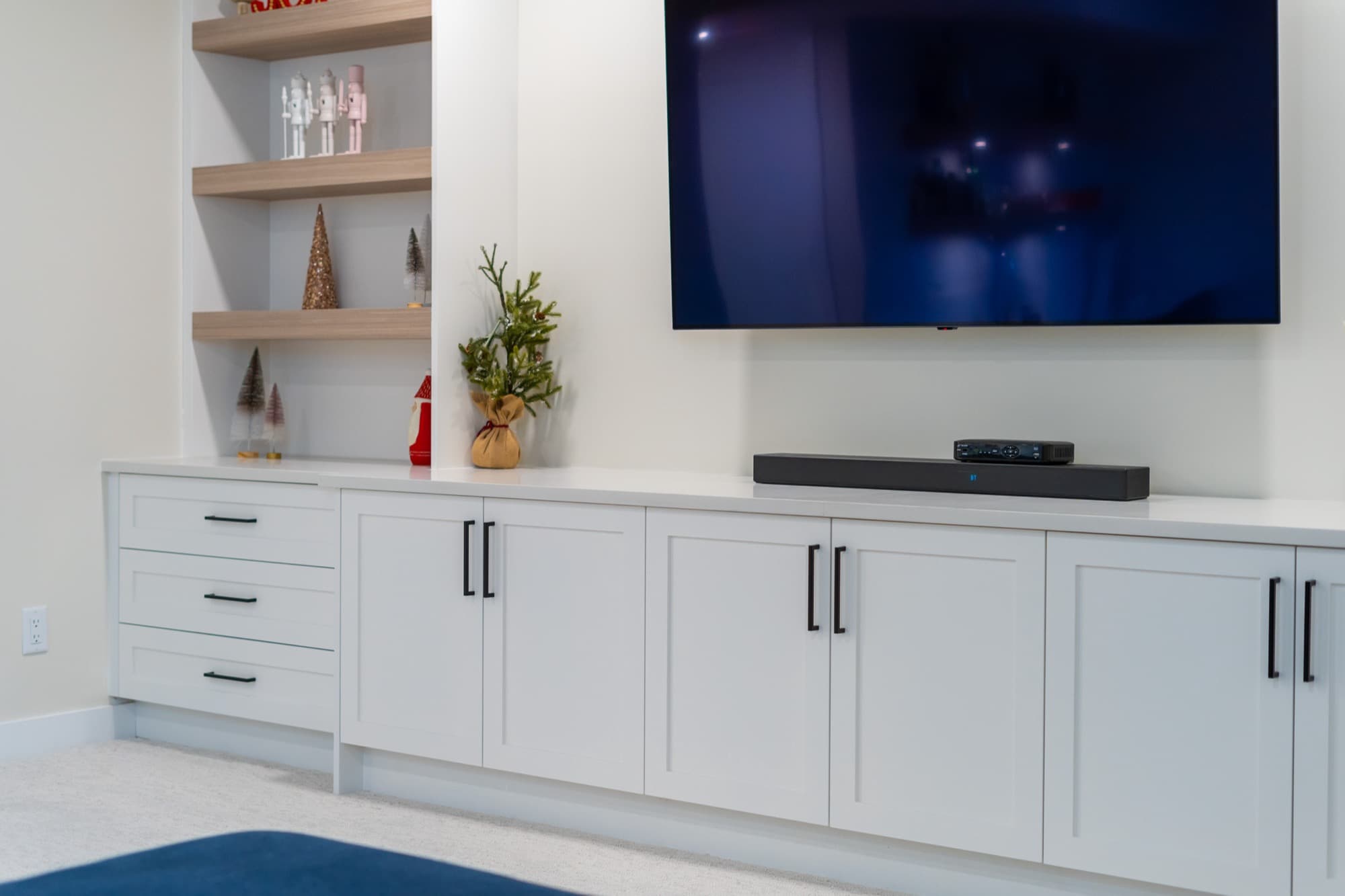 Basement built-in entertainment cabinet with soundbar, angled view