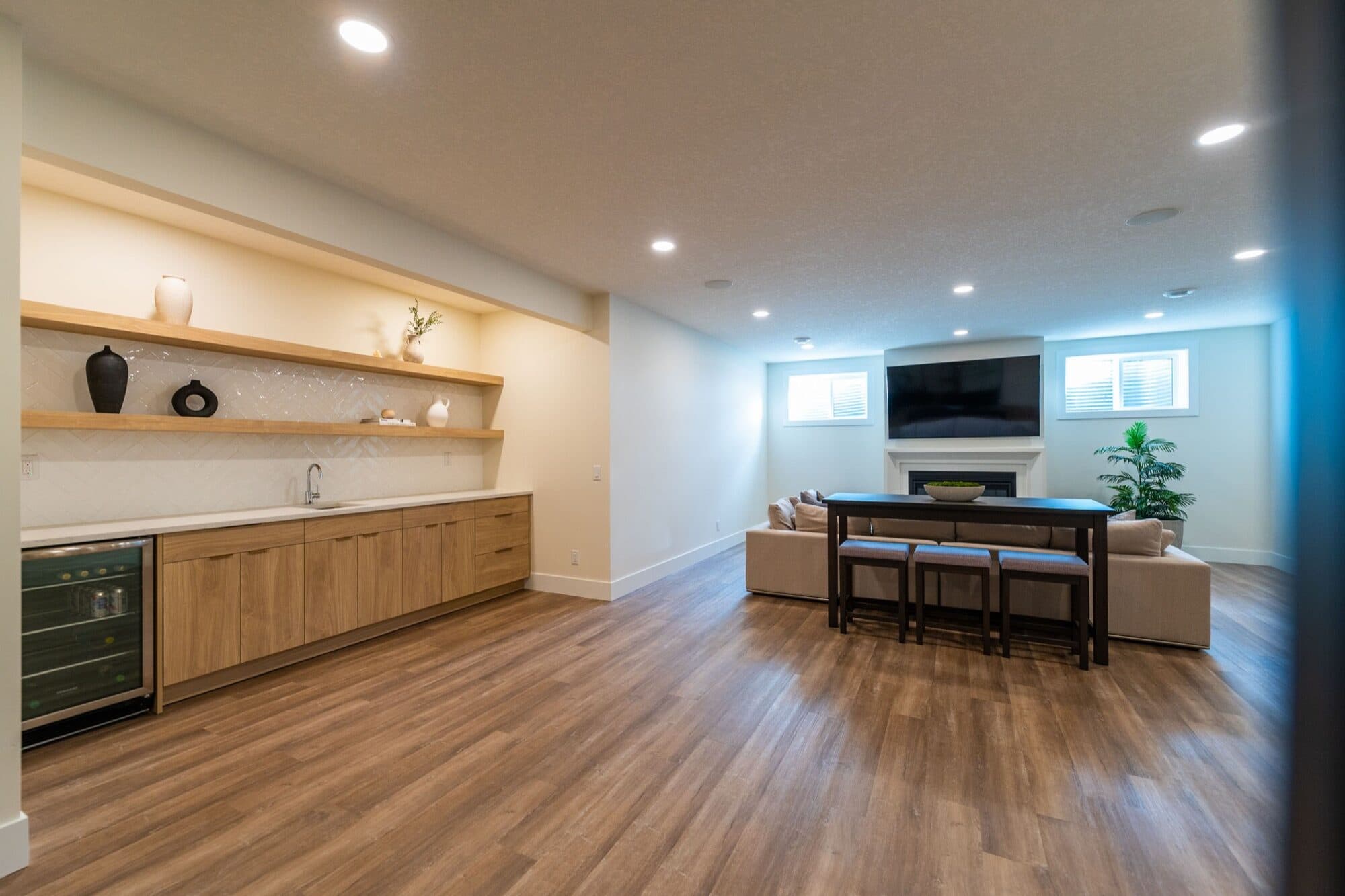 Basement rec room with oak bar, fireplace and TV, full-width view