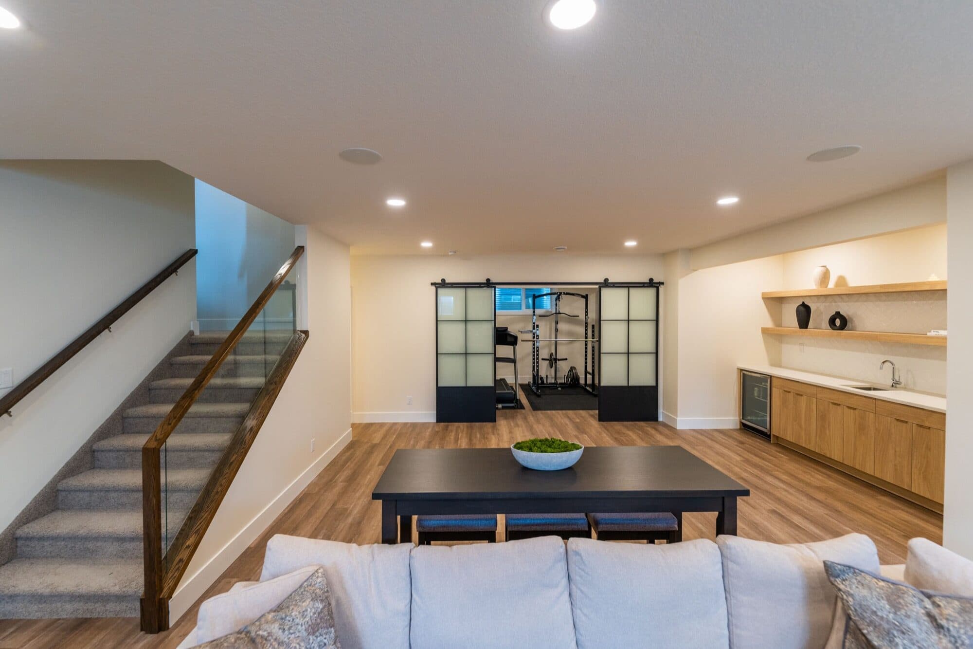 Basement open rec room with gym barn doors and wet bar