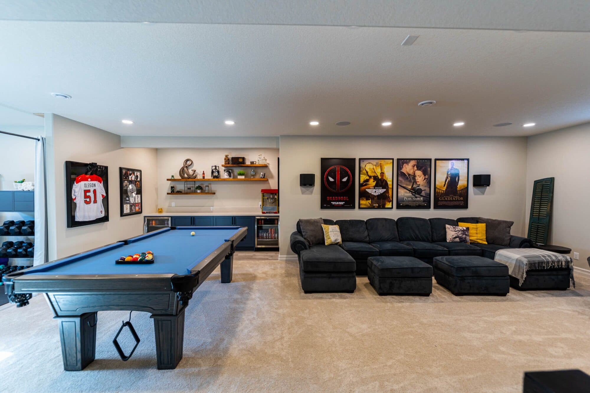 Basement rec room with pool table, movie posters and bar seating