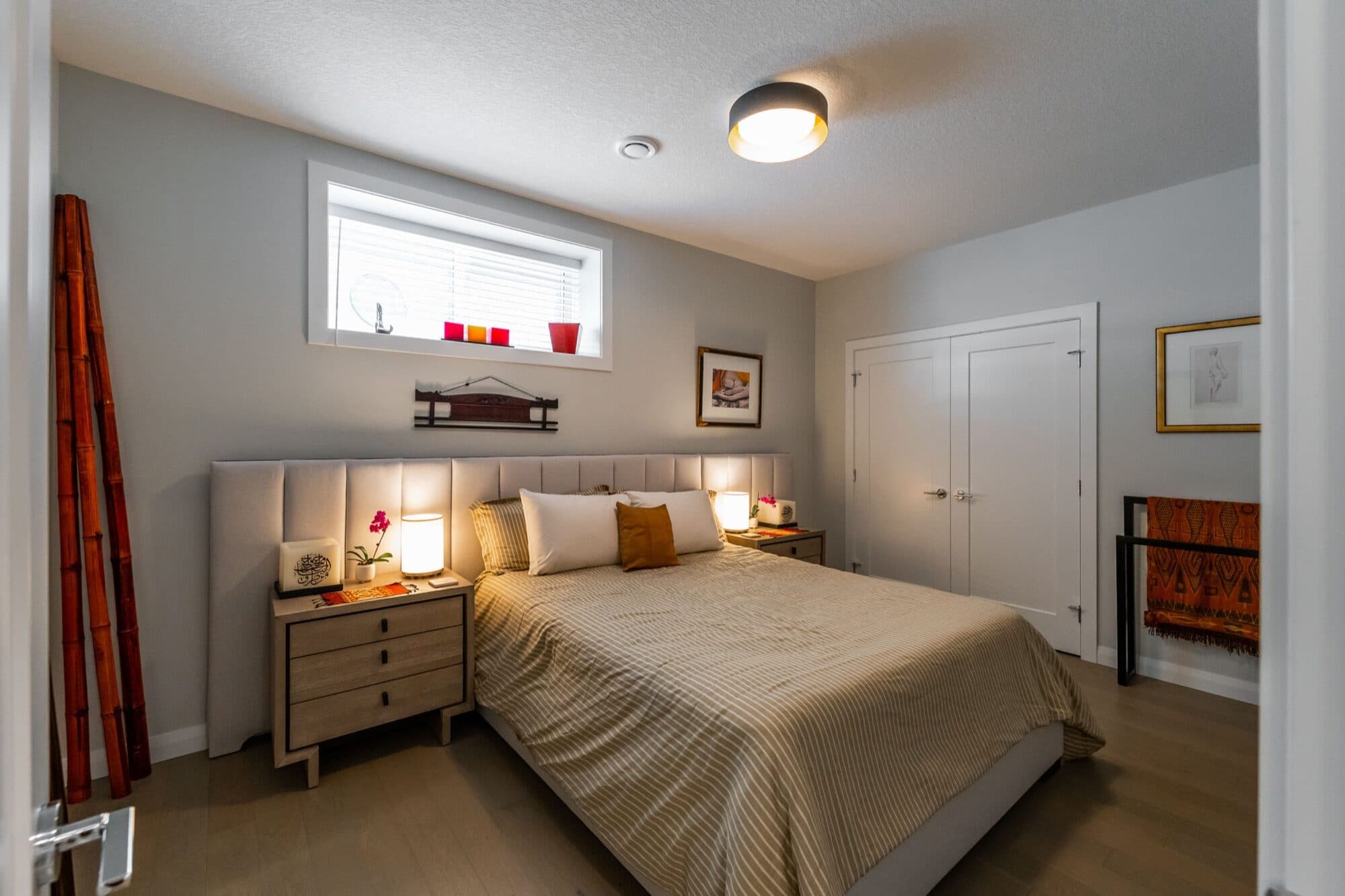 Legal suite basement bedroom in warm tones with egress window