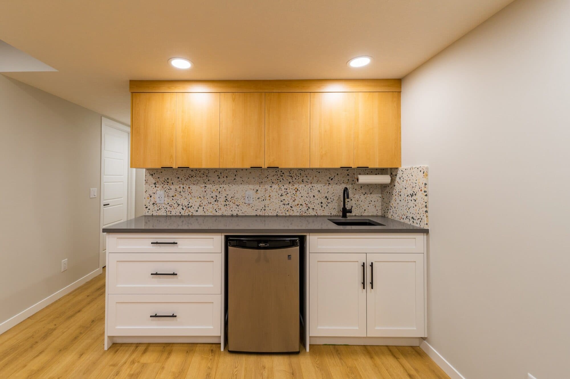 Legal suite kitchenette with honey oak cabinets and terrazzo backsplash
