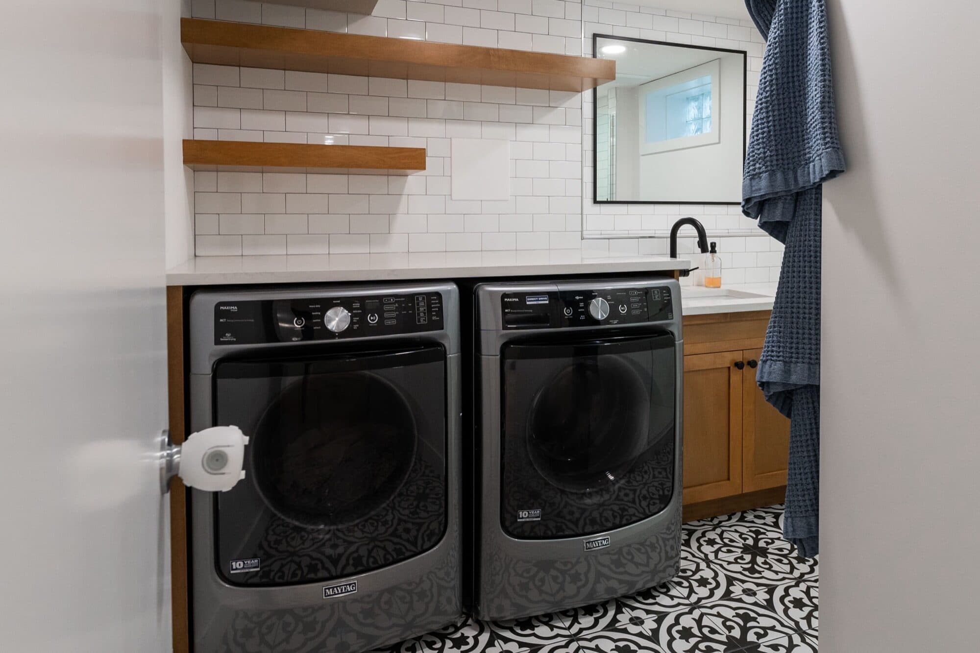 Legal suite laundry room with subway tile and patterned floor