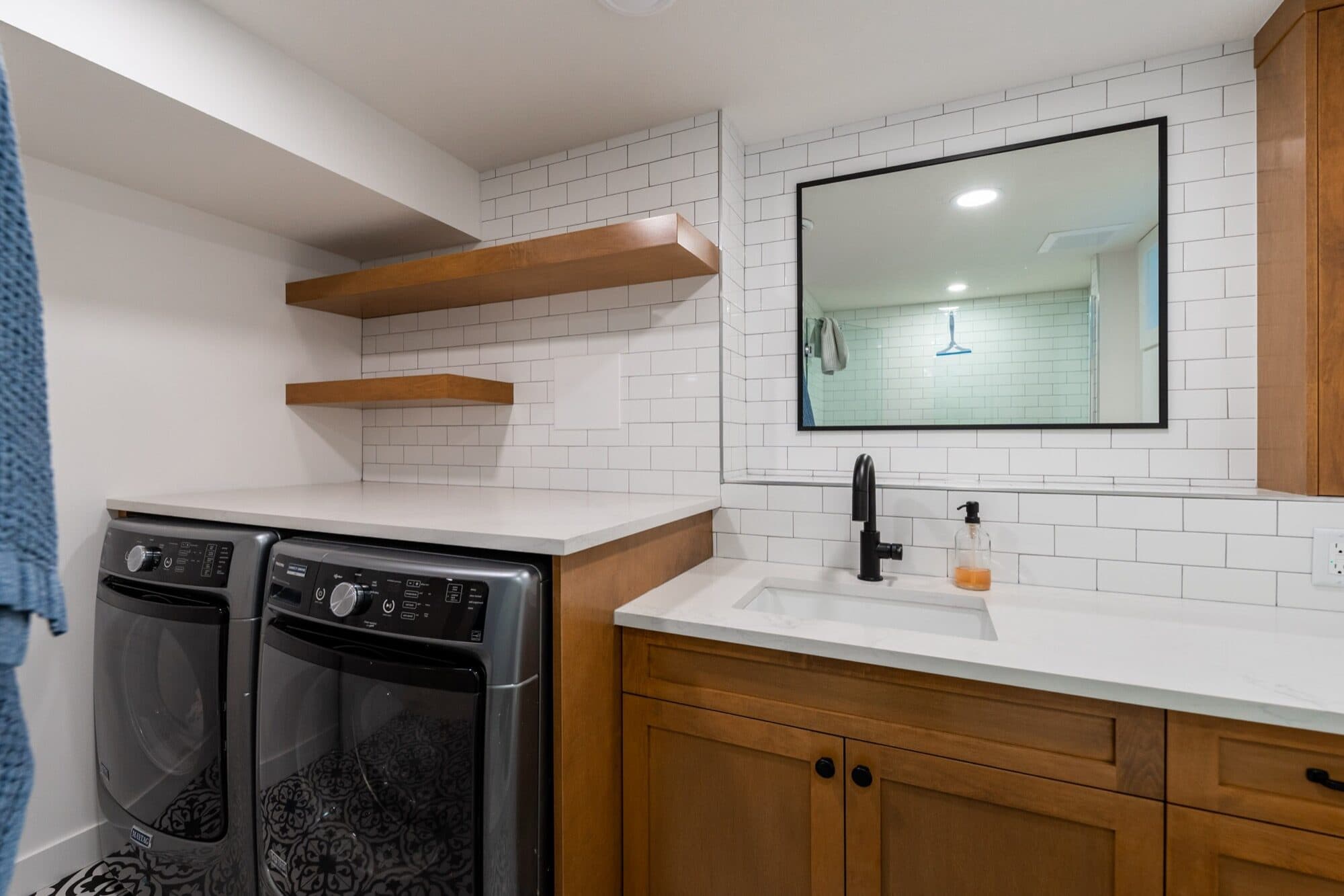 Legal suite laundry room with wood cabinet and sink, second angle