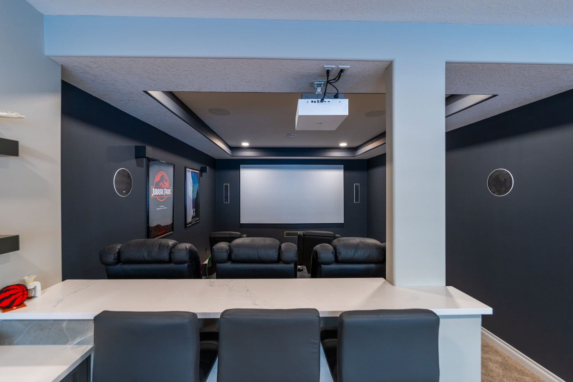 Basement home theatre with projector screen, leather seats and bar counter