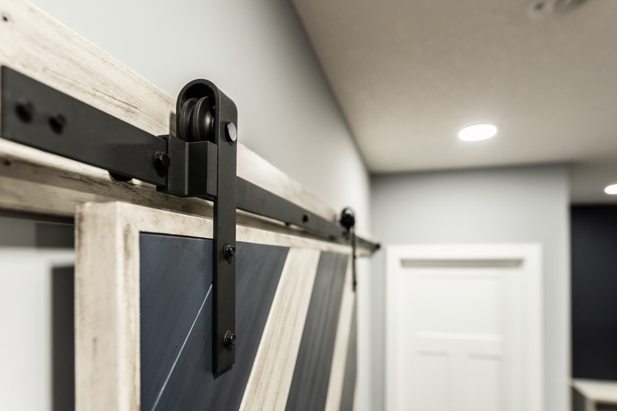 Close-up barn door hardware roller detail in basement corridor