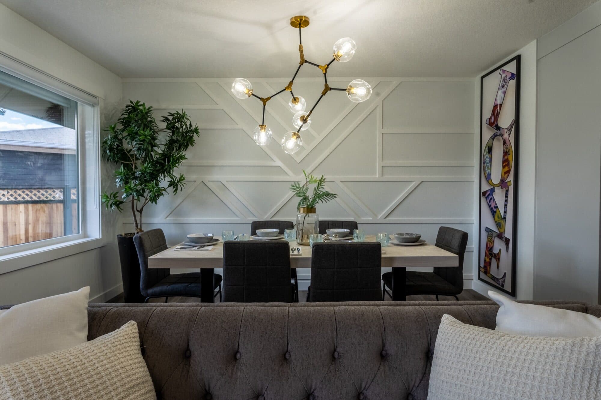 Legal suite dining room with wainscot wall, chandelier and set table