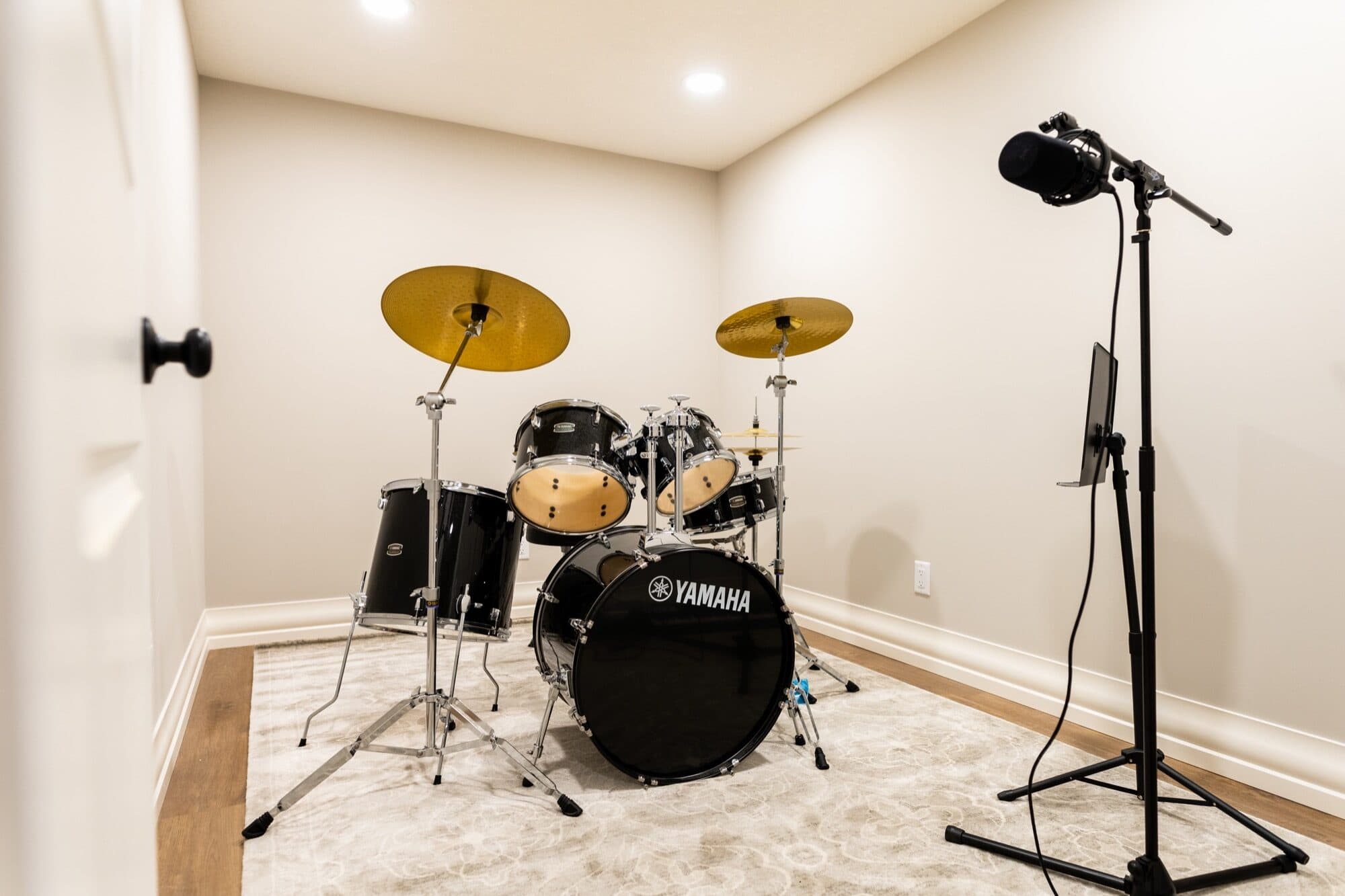 Finished basement music room with drum kit and mic stand
