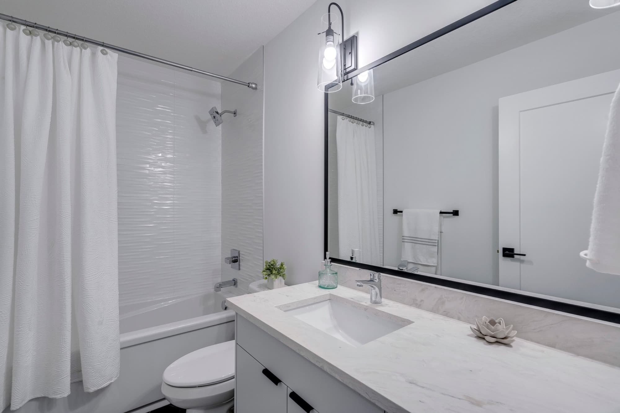 Clean basement bathroom with single vanity and marble countertop